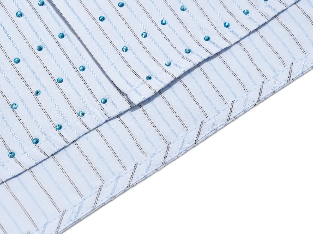 A close-up of a light blue and white striped fabric with thin vertical stripes and small teal rhinestone embellishments, shown folded on a white background. TCH Blue Striped Tie Detail Button-Up Shirt