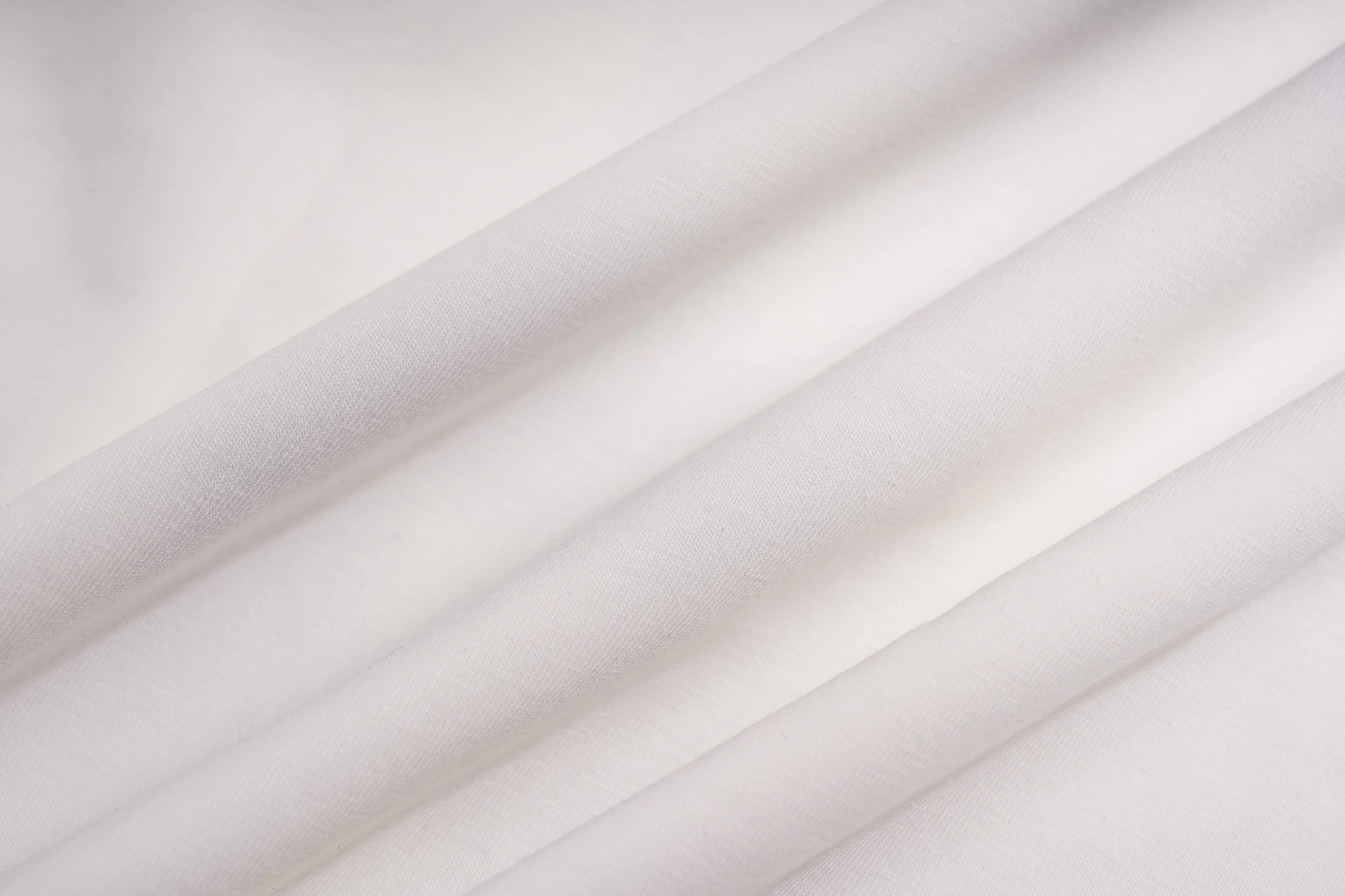 A close-up of draped white fabric with soft folds and a smooth texture. TCH Brush Logo Graphic Oversized T-Shirt