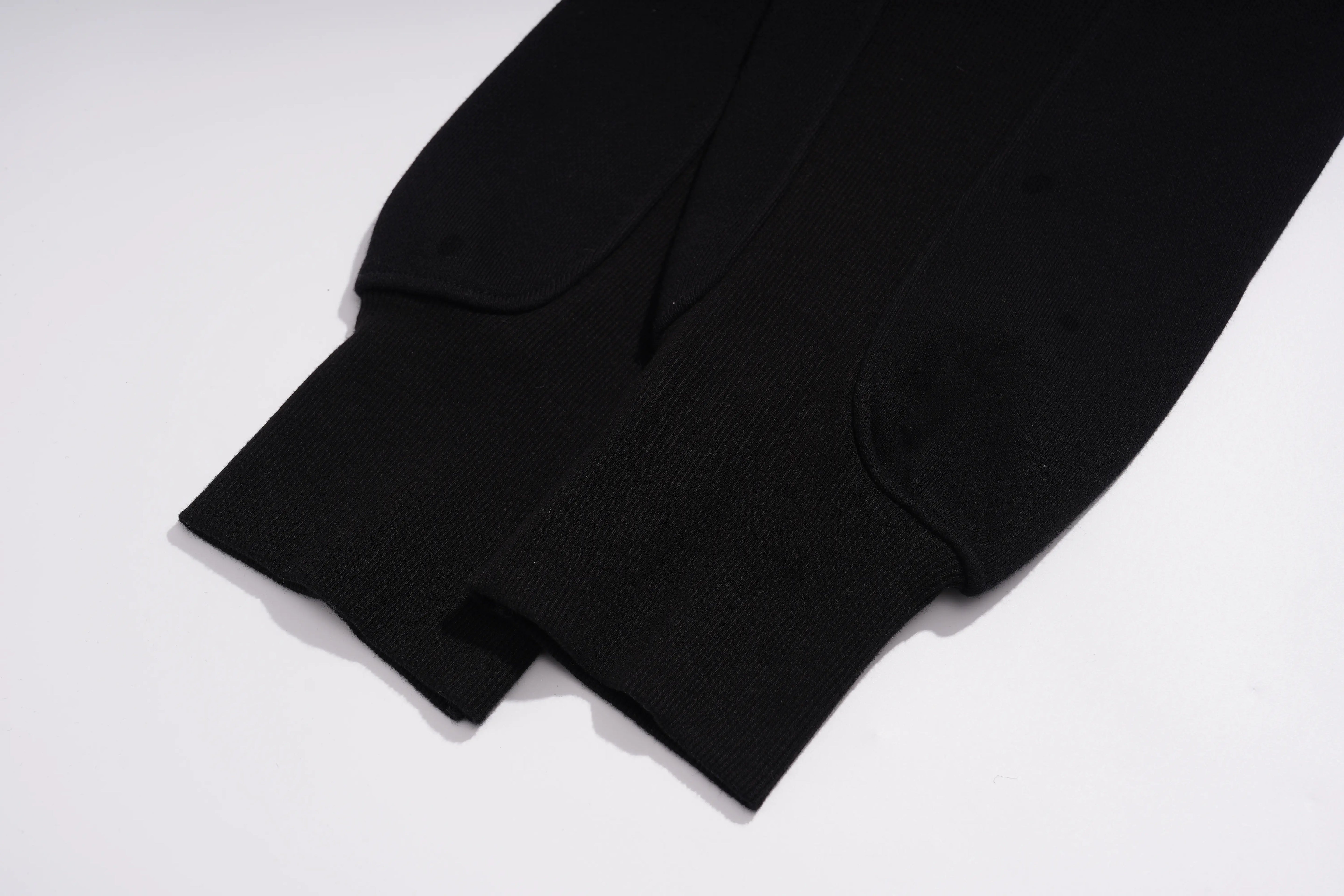 Close-up of a black knit garment, showing the ribbed cuff and folded hem on a plain white background. TCH Butterfly Rhinestone Graphic Black Jogger Pants