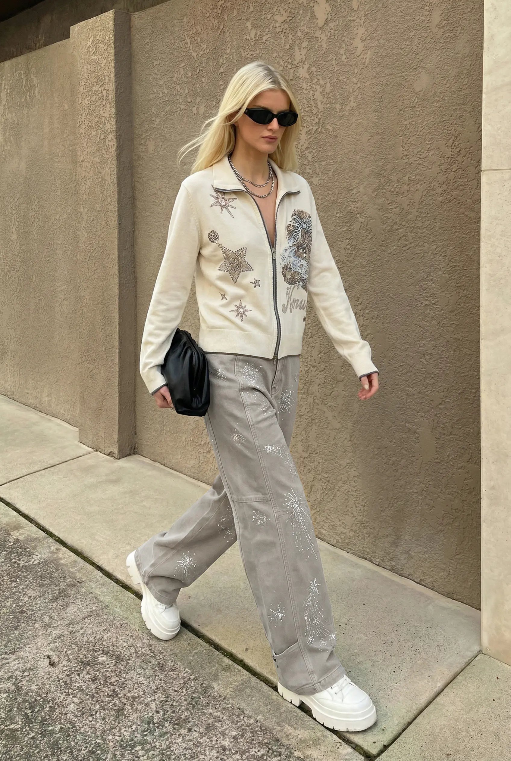 Woman in a stylish outfit with a beige jacket and gray pants walking on a sidewalk. TCH Celestial Firework Rhinestone Wide-Leg Pants
