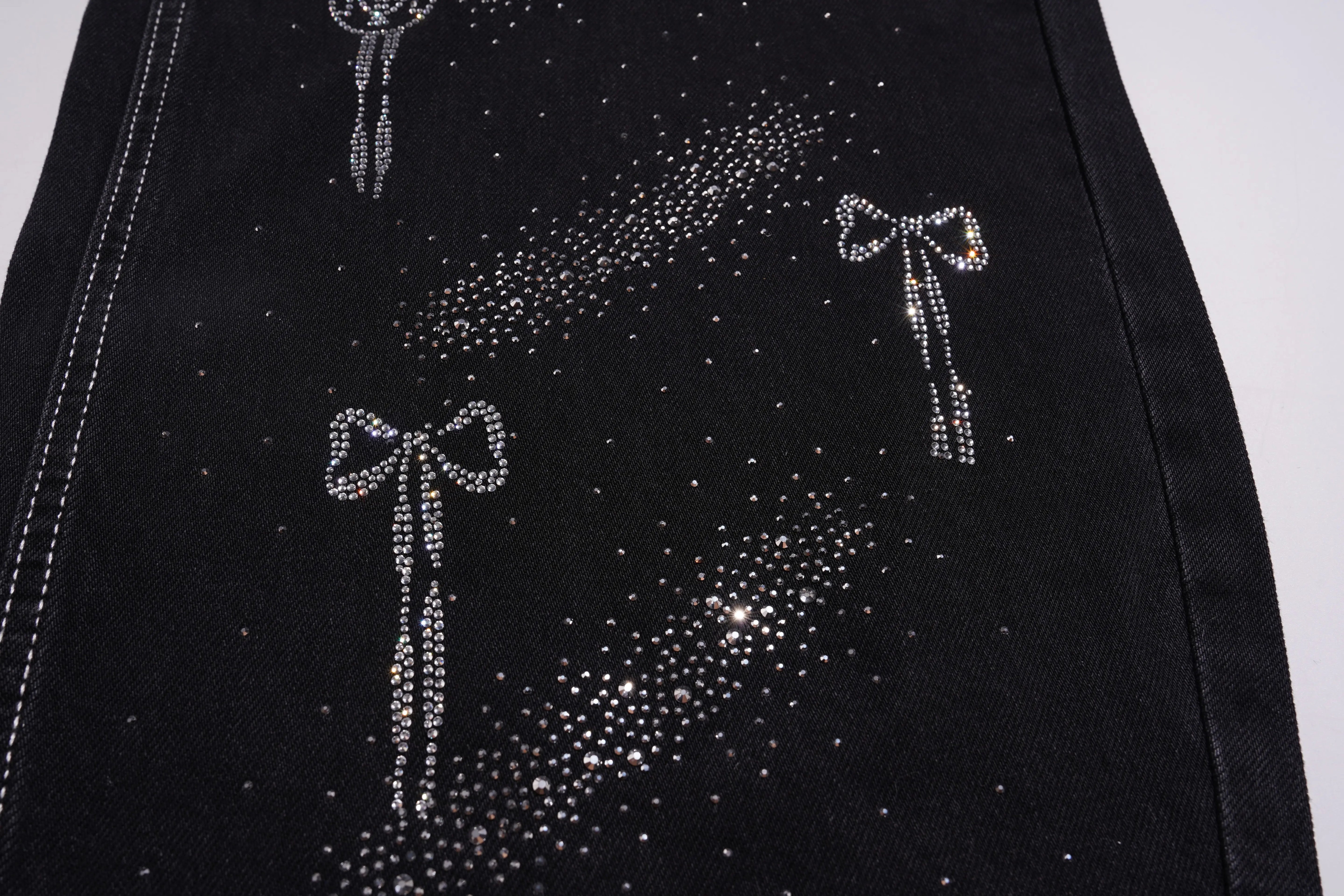 Black fabric with silver rhinestone bows and dots on a white background, TCH Celestial Rhinestone Wide-Leg Black Jeans