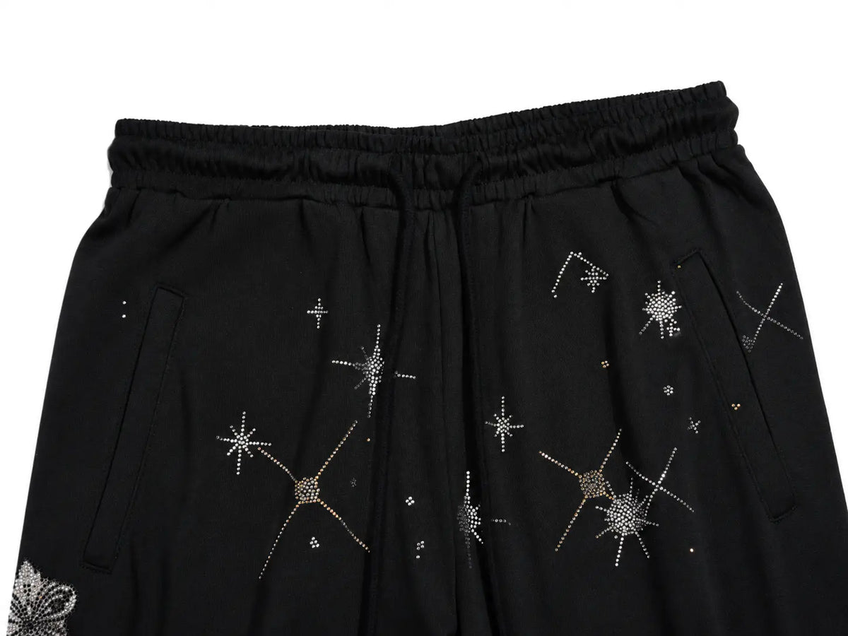 Black drawstring shorts with silver and gold rhinestone starburst and constellation patterns, shown against a plain white background. TCH Celestial Rhinestone Wide-Leg Sweatpants