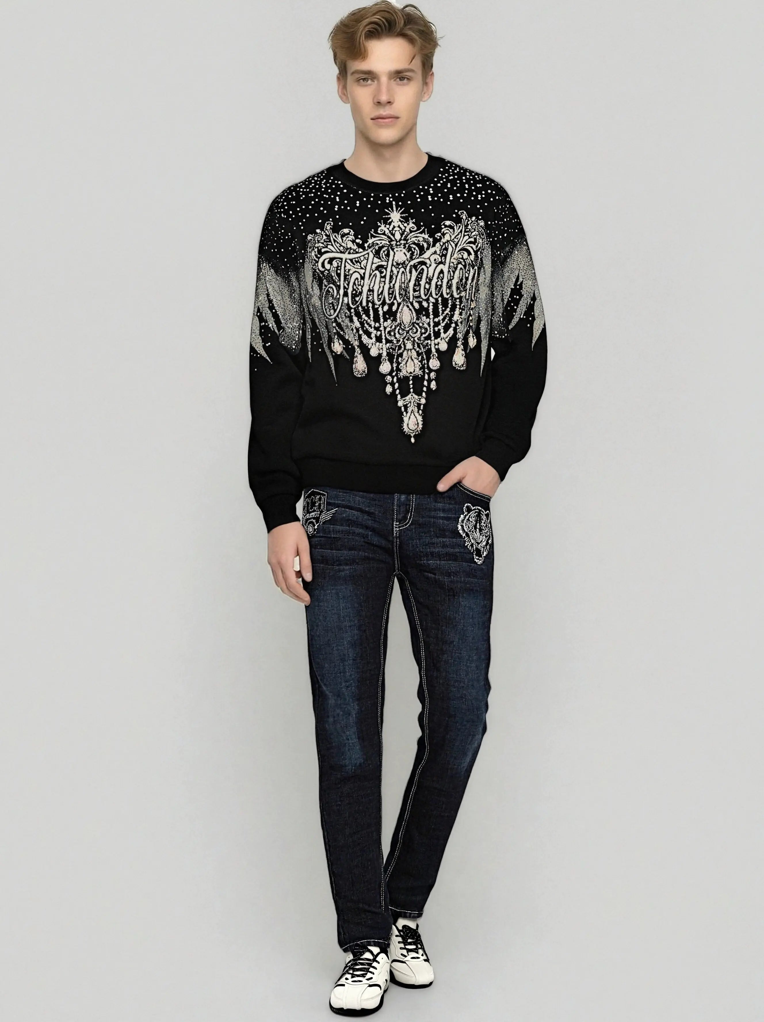 Man wearing a black sweater with decorative elements and blue jeans on a light gray background, TCH Celestial Wing Graphic Crewneck Sweatshirt