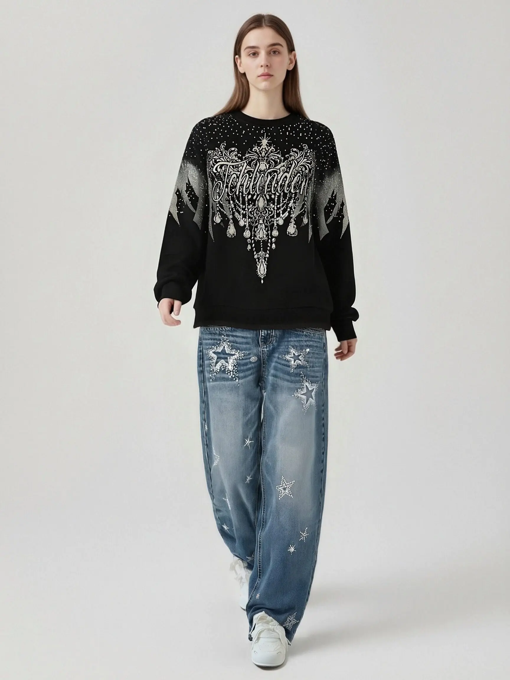 Person wearing a black sweater with white patterns and blue jeans with star designs on a white background, TCH Celestial Wing Graphic Crewneck Sweatshirt