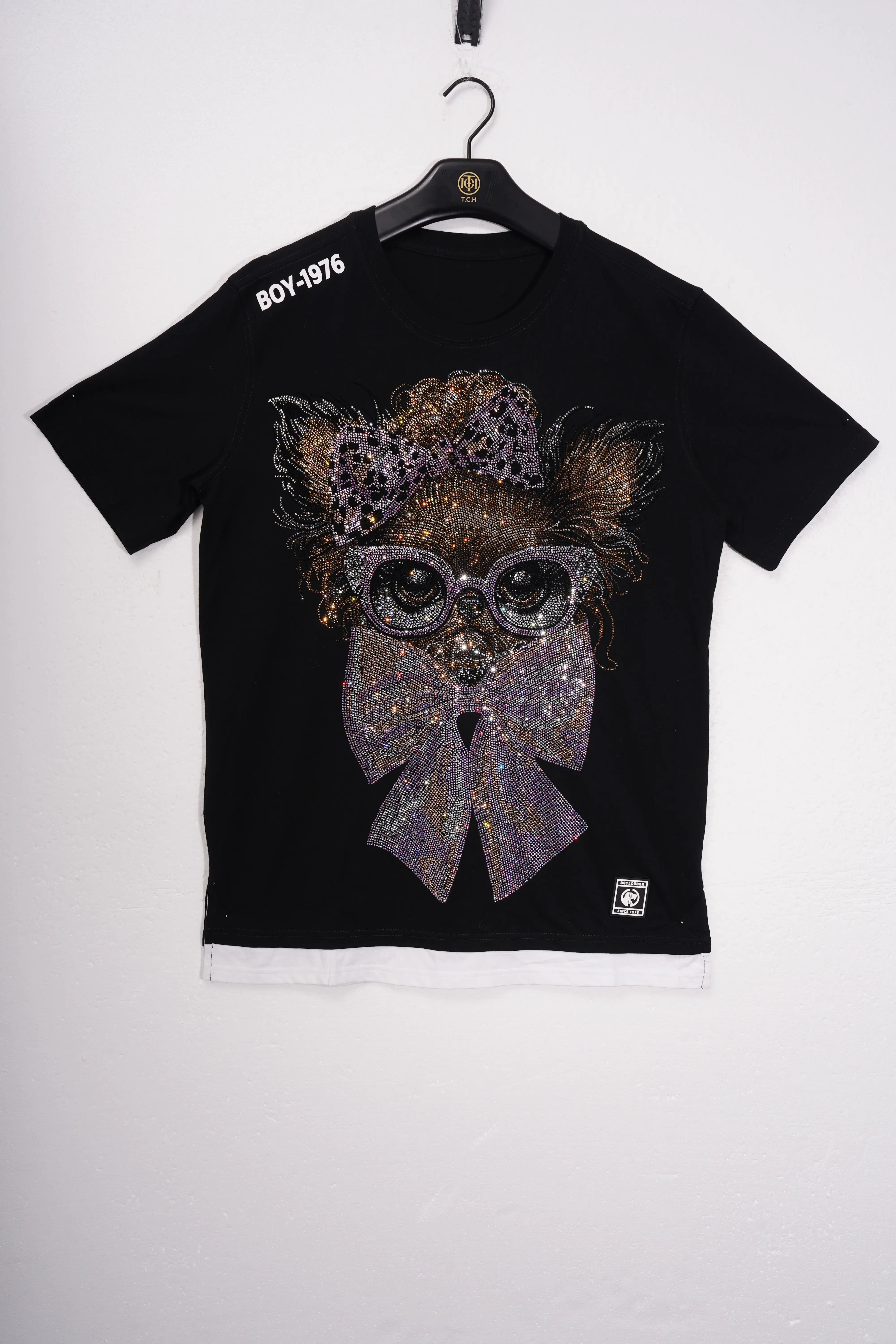 Black t-shirt with a decorative design of a face with glasses and a bow, hanging on a white background. TCH Chihuahua Bow Rhinestone T-Shirt