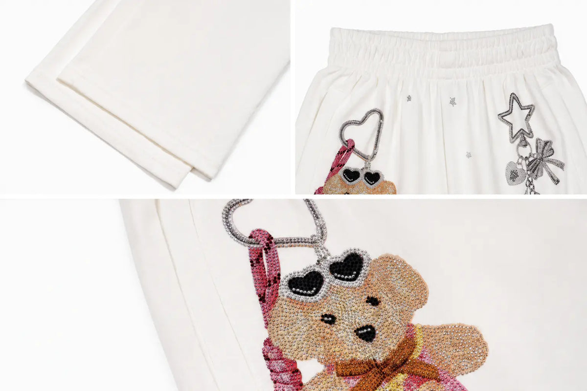 White embroidered shorts featuring a teddy bear design embellished with rhinestones, sunglasses, and a pink scarf, shown in a multi-view collage. TCH Crystal Bear Graphic Wide-Leg Sweatpants