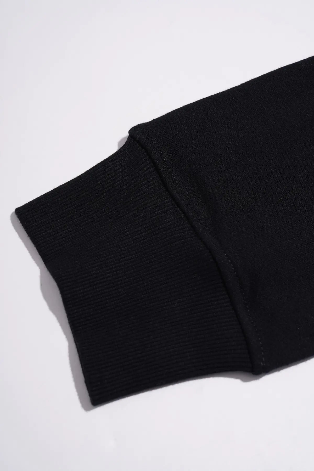 Close-up of a black ribbed knit sleeve cuff on a white background. TCH Crystal Eagle Graphic Zip Up Hoodie
