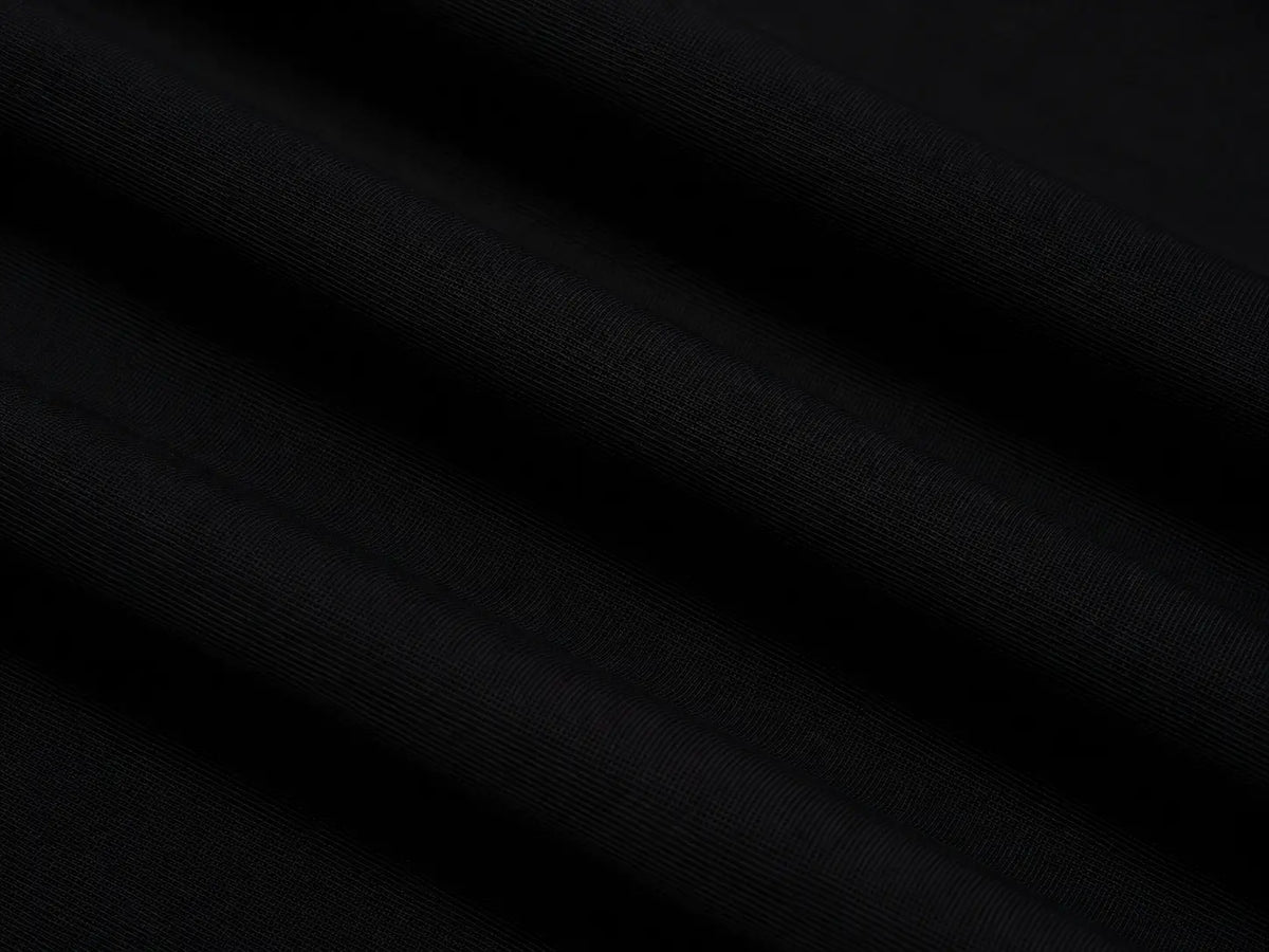 A close-up of black fabric with soft diagonal folds and a fine woven texture. TCH Crystal Wing Graphic Zip Up Hoodie