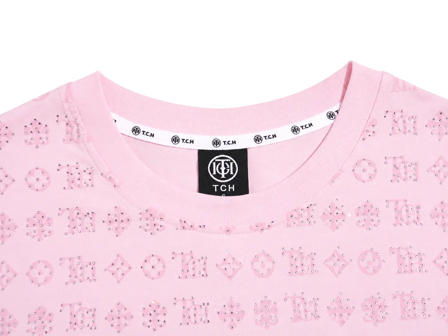 Close-up of a light pink TCH crewneck top featuring an all-over embroidered monogram pattern, with a black neck label and white inner collar trim. TCH Cute Hoodie Teddy Bear Rhinestone Oversized T-Shirt Dress