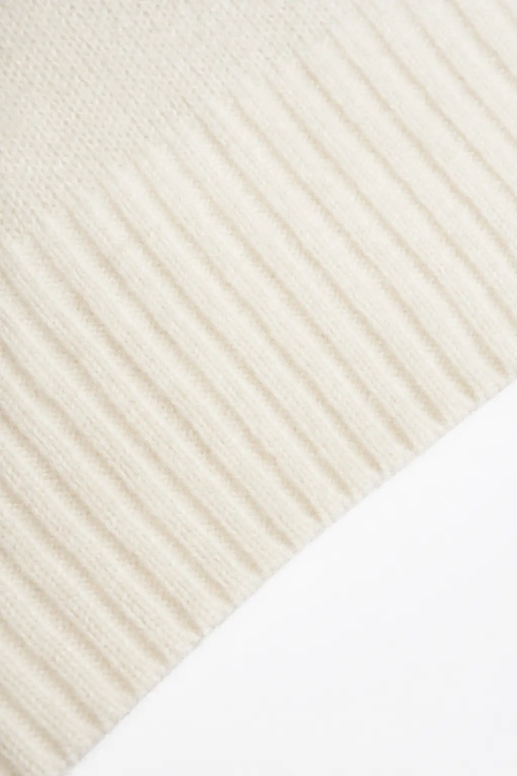 Close-up of a cream-colored ribbed knit fabric, showing the texture and pattern of the knit stitches. TCH Cute Puppy Star Graphic Knit Sweater