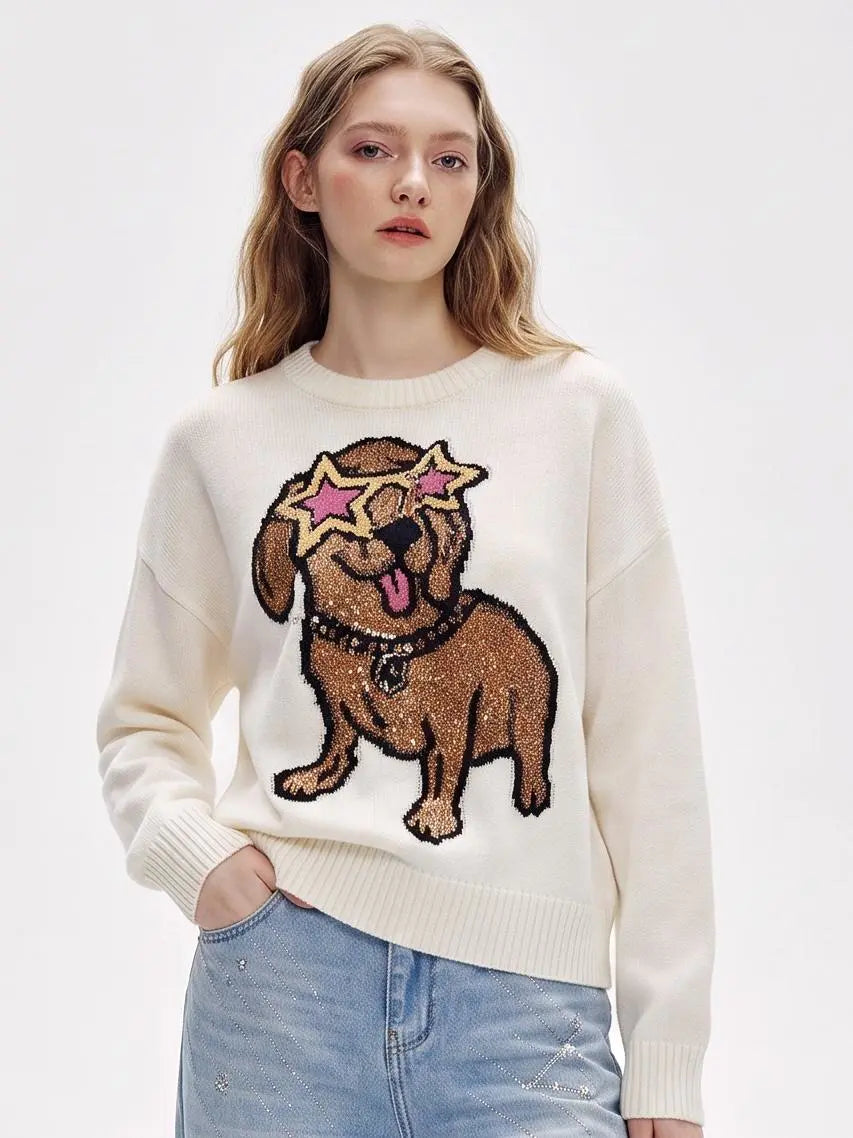 A woman wearing a cream-colored knit sweater with a large brown dog graphic on the front, styled with light blue jeans against a plain white studio background. TCH Cute Puppy Star Graphic Knit Sweater