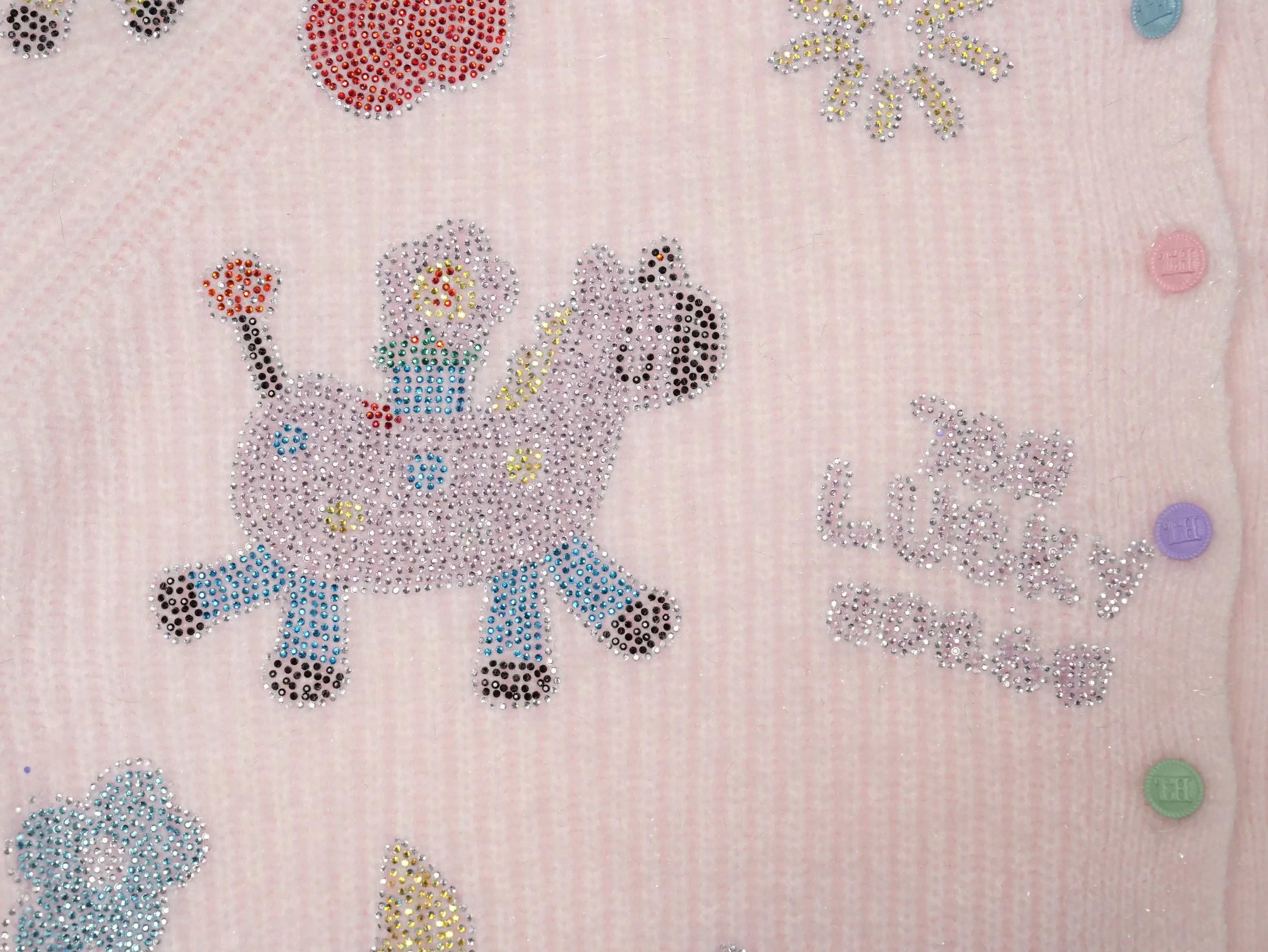 Close-up of a light pink knit garment featuring a colorful rhinestone-embellished unicorn design and decorative text on the front. TCH Cute Rhinestone Animal Garden Knit Cardigan