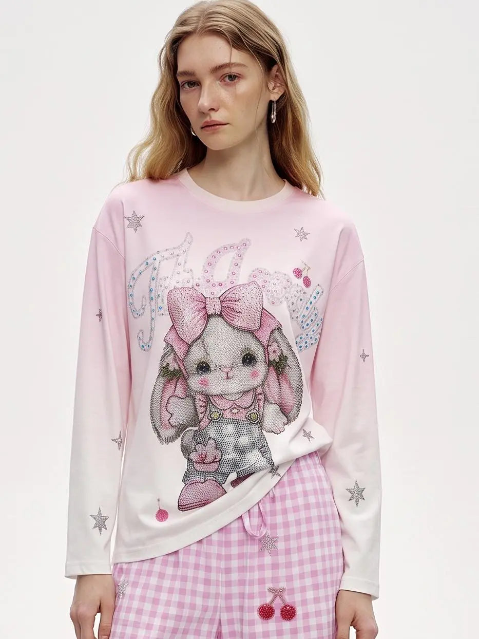 A model wearing a light blue denim jacket with various embroidered patches, including a teddy bear on the left chest and cherries on the sleeve, styled over a white t-shirt and dark pants. TCH Cute Rhinestone Cat Graphic Pink Long Sleeve T-Shirt