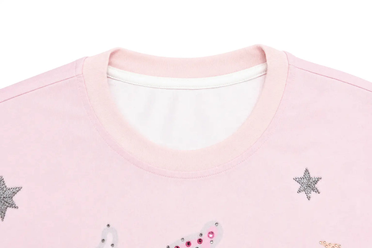 Close-up of a light pink crewneck sweatshirt featuring silver rhinestone star embellishments and a small white rhinestone graphic on the front. TCH Cute Rhinestone Cat Graphic Pink Long Sleeve T-Shirt