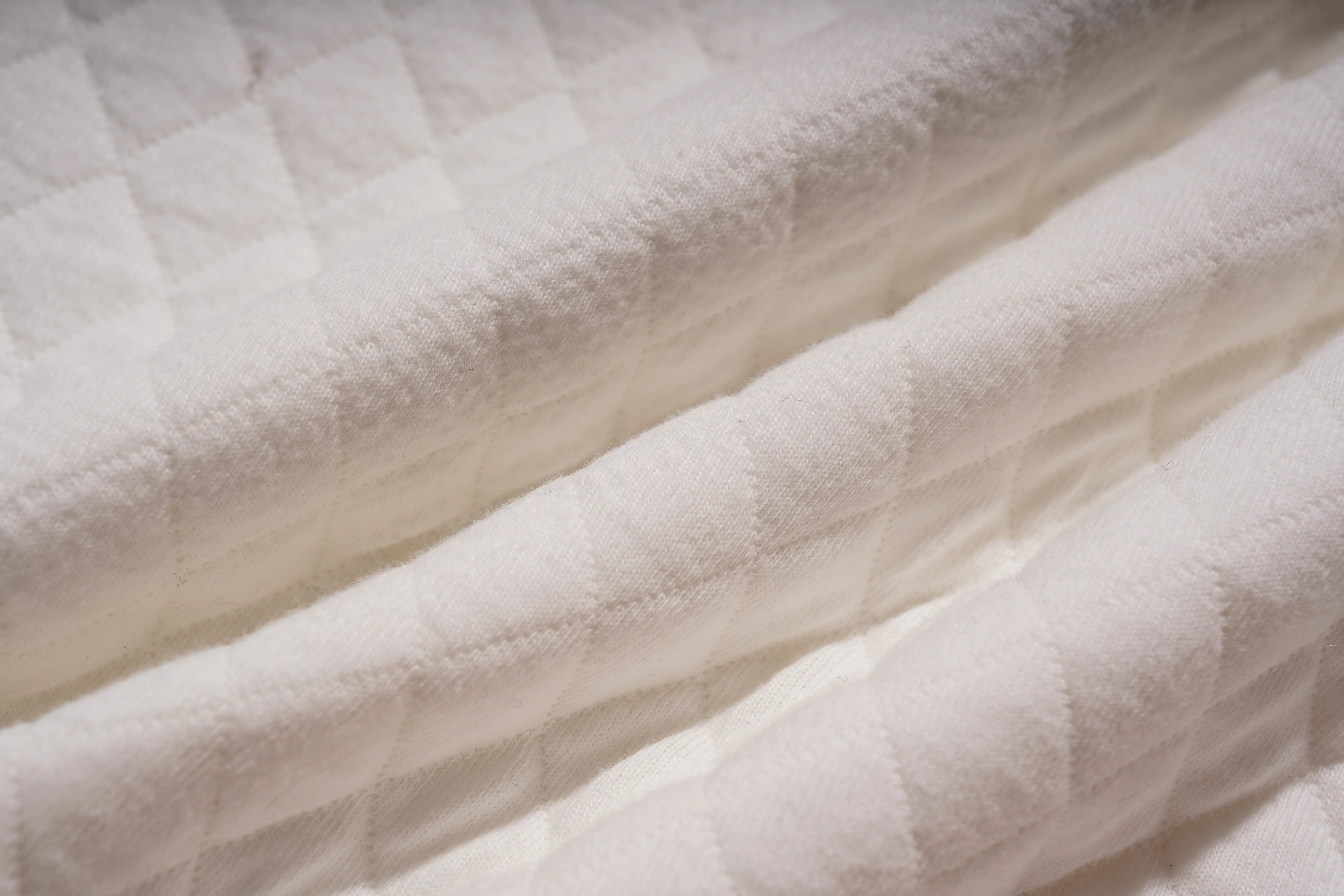 Close-up of white quilted fabric texture