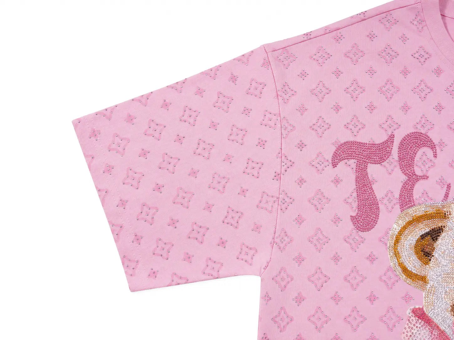 A close-up of a pink short-sleeve garment, likely a dress or tunic, featuring a repeating tonal monogram pattern, a large pink decorative letter on the front, and a partially visible gold and white graphic on the lower right, set against a plain white background. TCH Cute Teddy Bear Rhinestone Oversized T-Shirt Dress