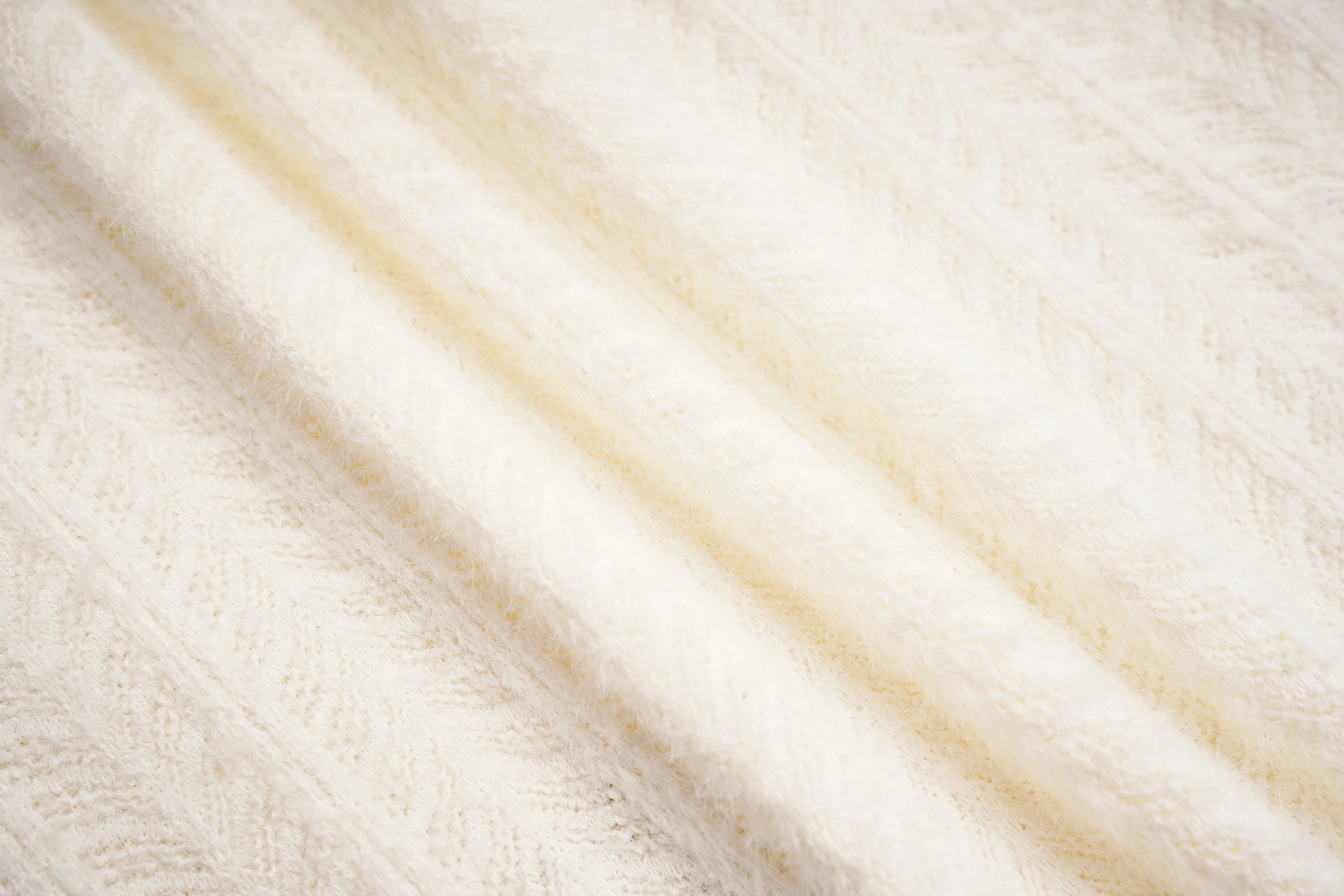 Close-up of beige fabric with wavy pattern, TCH Dual-Layer Mesh V-Neck Rhinestone Bow Beige Crop Turtleneck Top