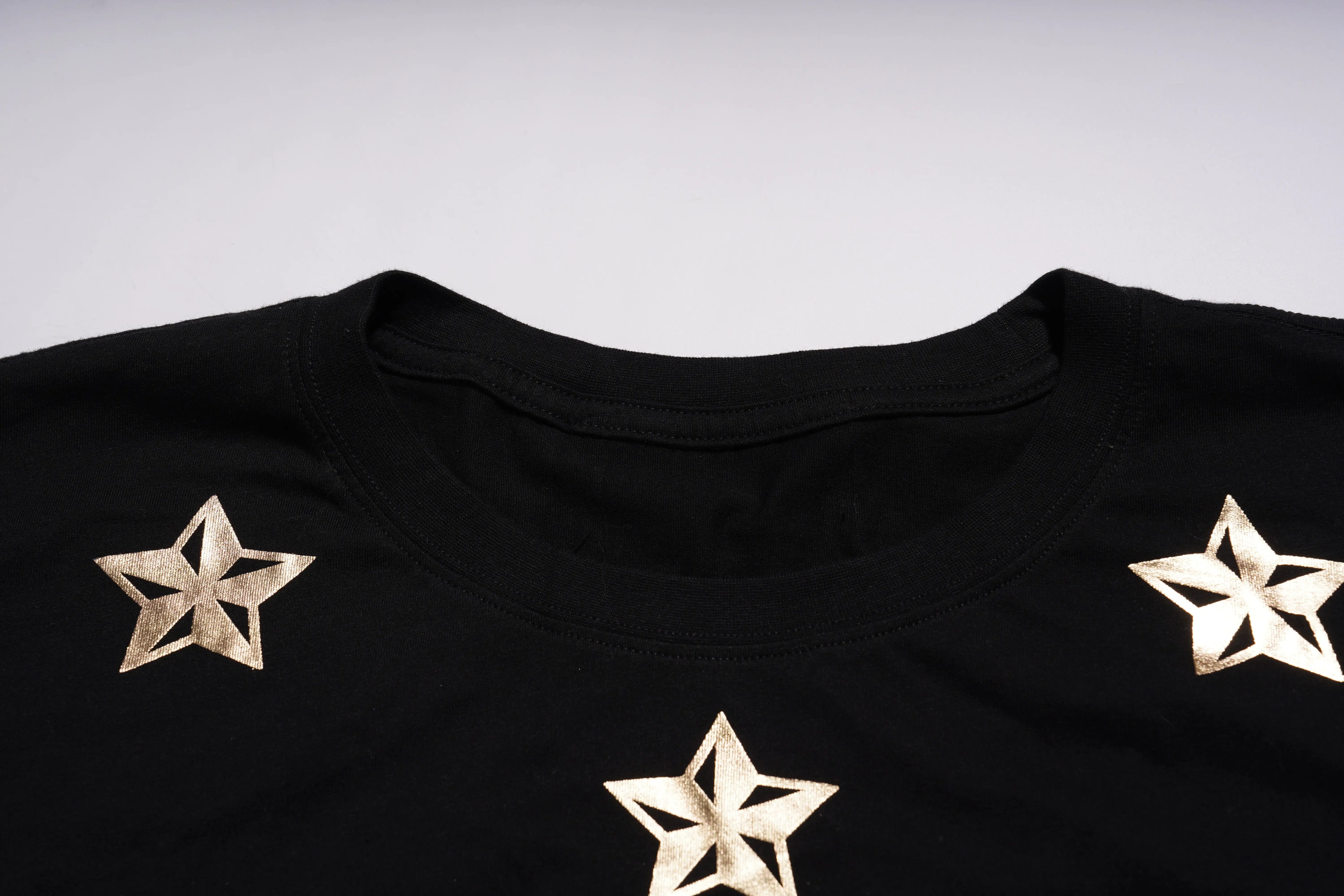 Black shirt with gold star designs on a light gray background, TCH Embroidered Floral Butterfly Rhinestone T-Shirt