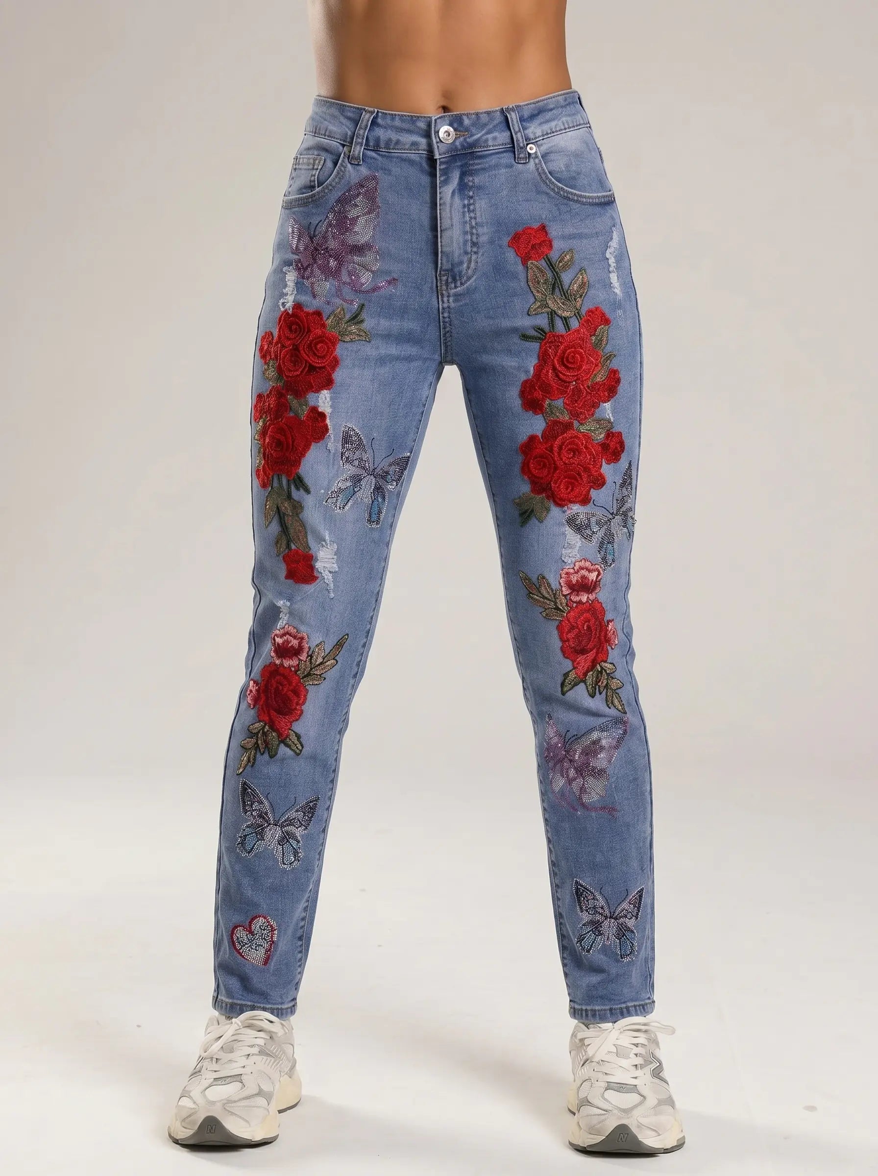 Blue jeans with red floral and butterfly designs on a white background, TCH Embroidered Rose & Rhinestone Butterfly Denim Jeans