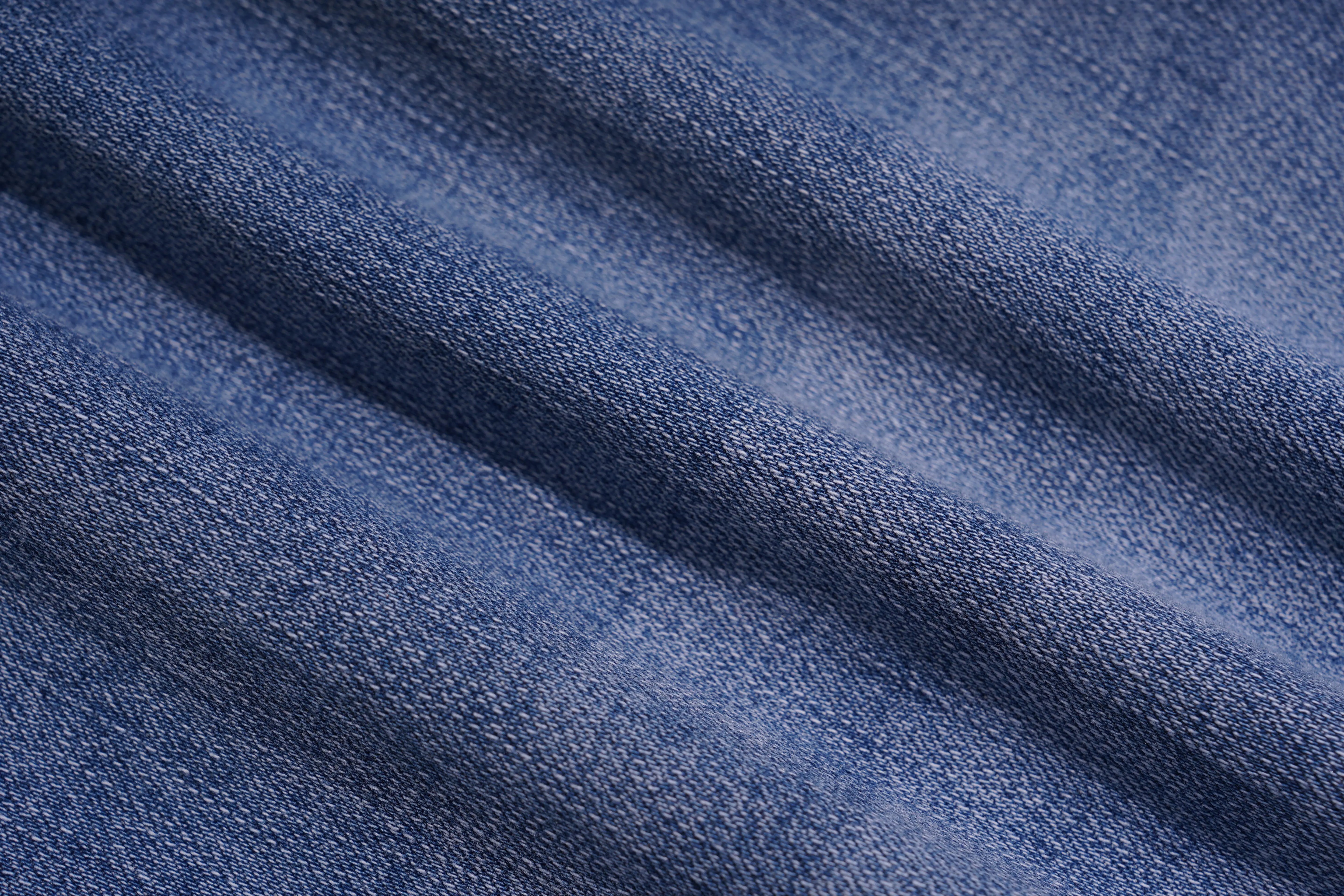 Close-up of blue denim fabric with visible texture, TCH Embroidered Rose & Rhinestone Butterfly Denim Jeans