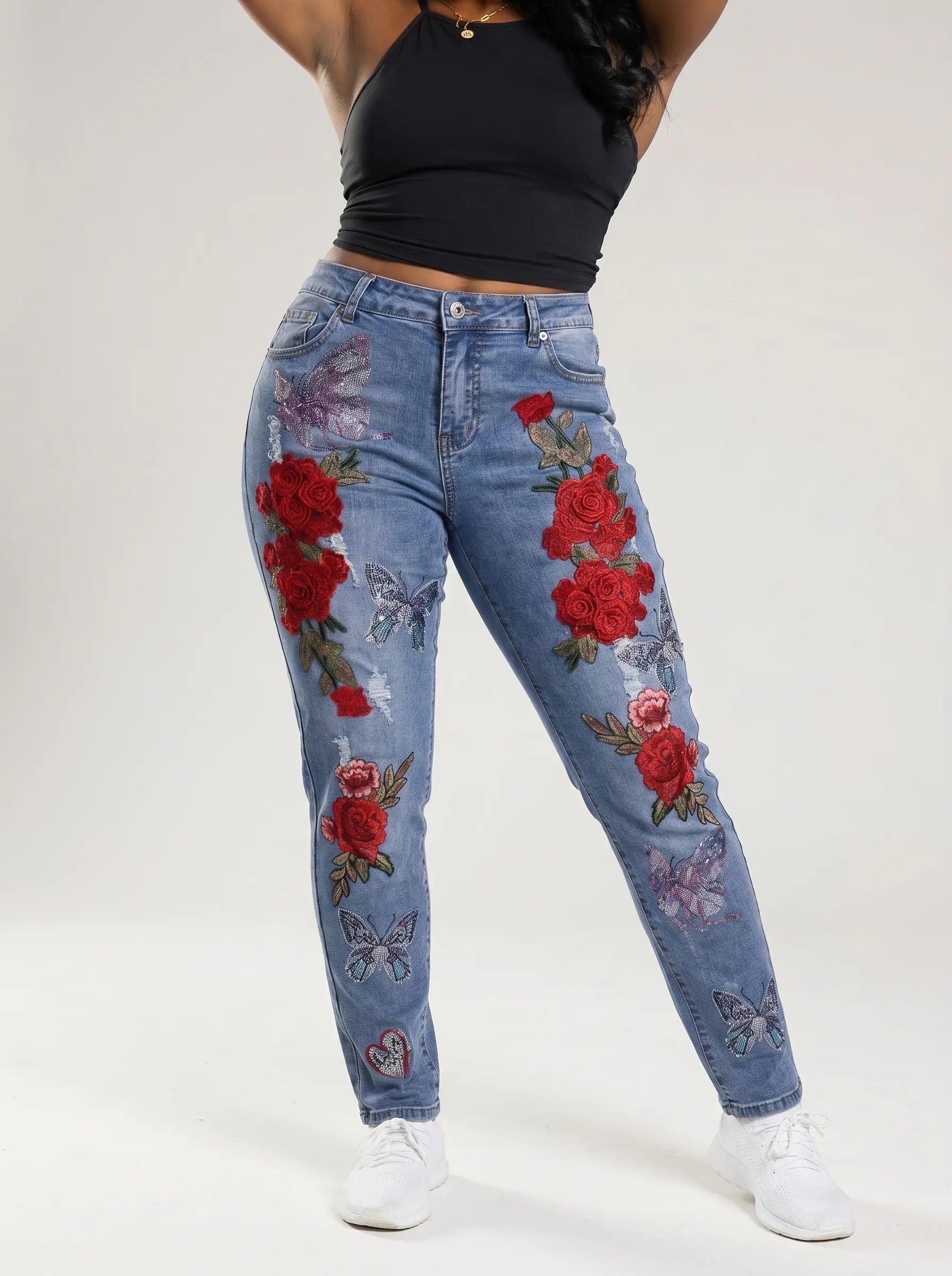Blue jeans with floral embroidery worn by a person on a white background, TCH Embroidered Rose & Rhinestone Butterfly Denim Jeans