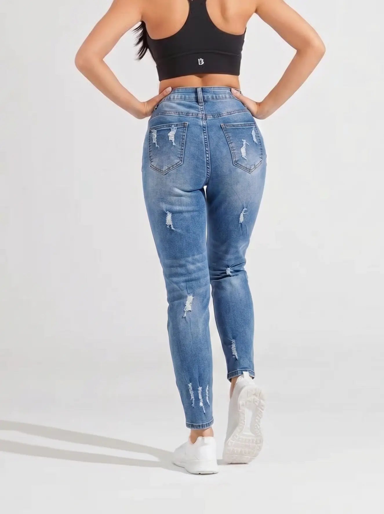Person wearing blue jeans and a black crop top on a white background, TCH Embroidered Rose & Rhinestone Butterfly Denim Jeans