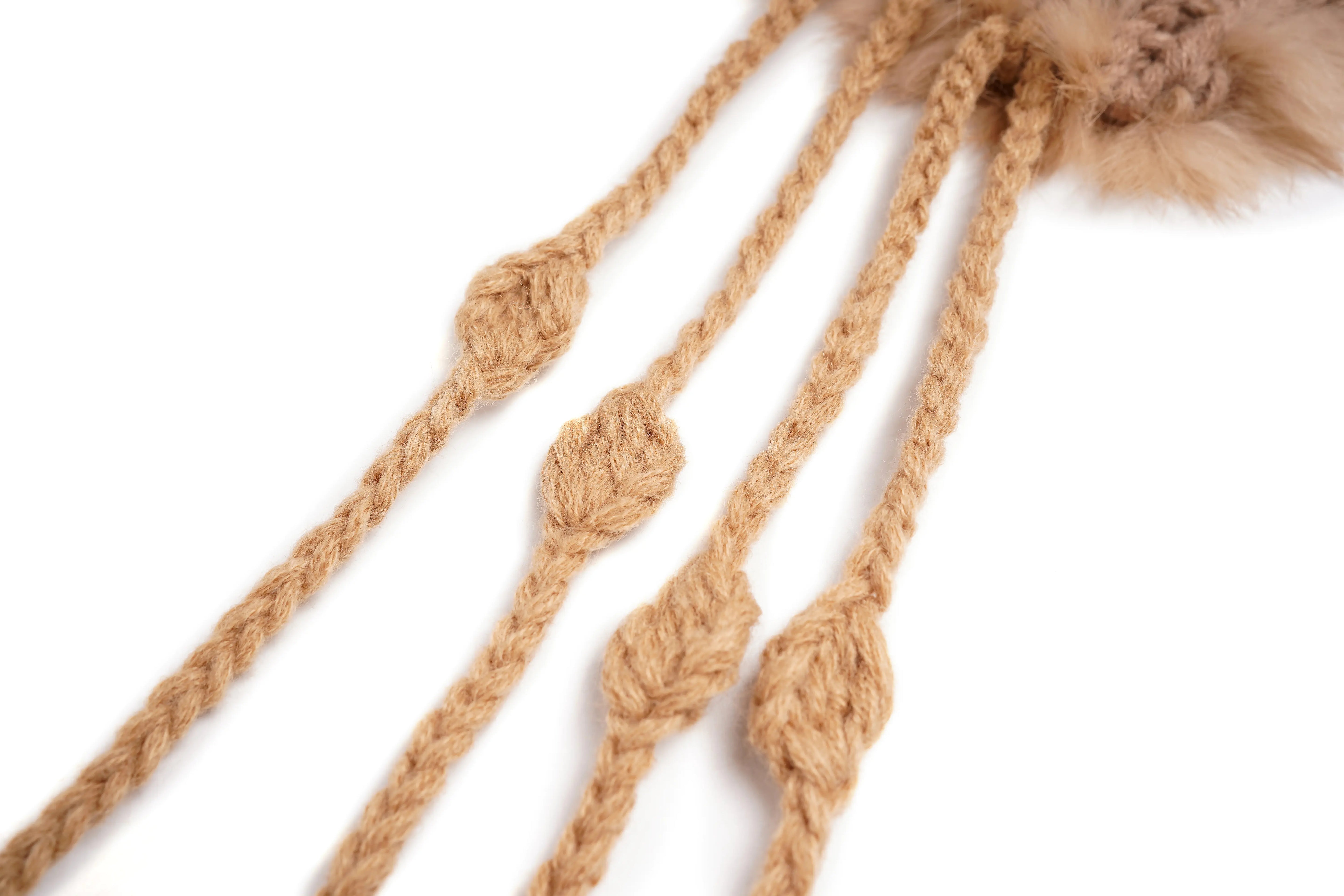 Close-up of tan braided rope with knotted details and a fluffy pom-pom on a white background. TCH Faux Fur Rhinestone Knit Tassel Winter Hat