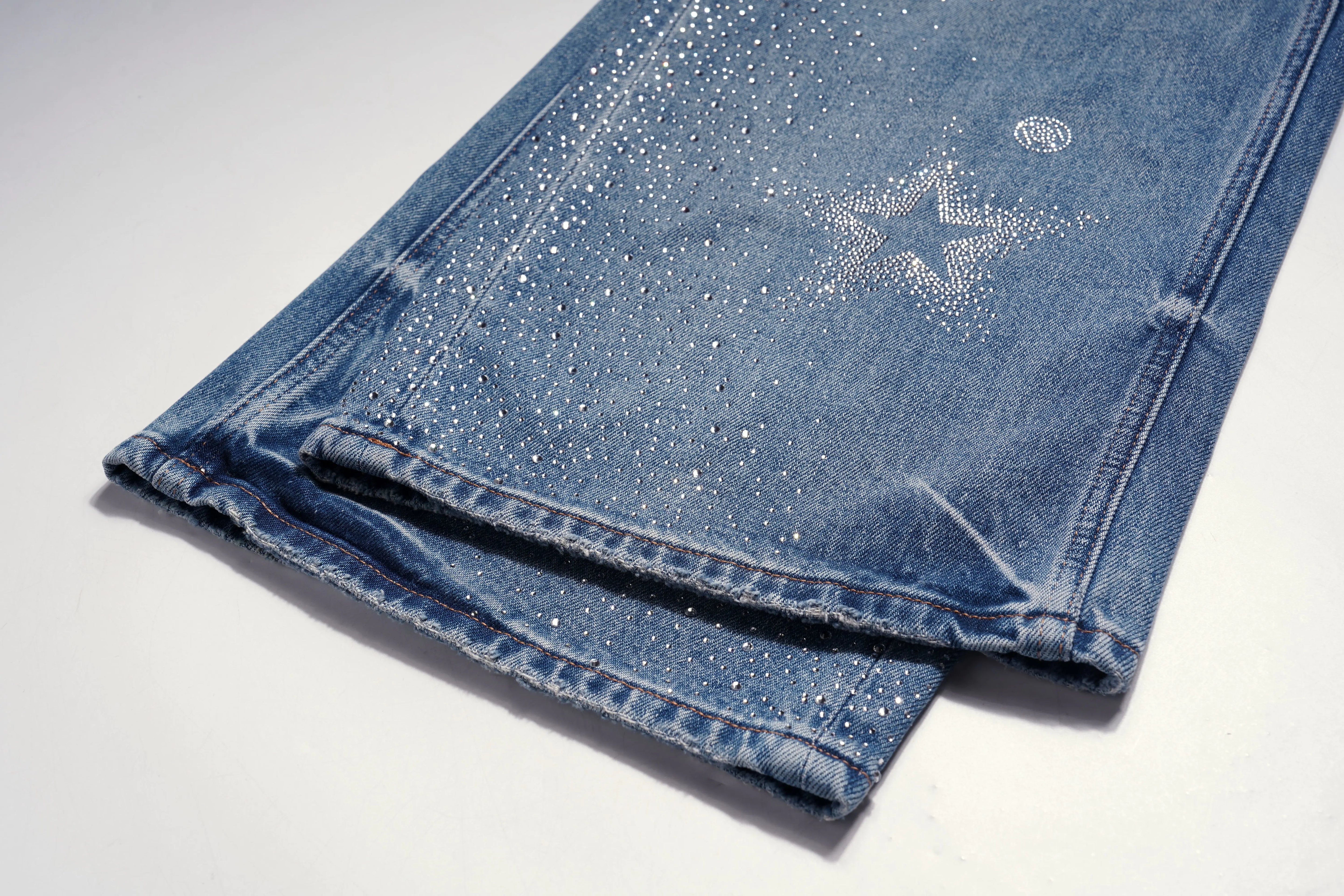 Folded blue jeans with glittery texture on a white background, TCH Firework Star Rhinestone Straight-Leg Blue Jeans