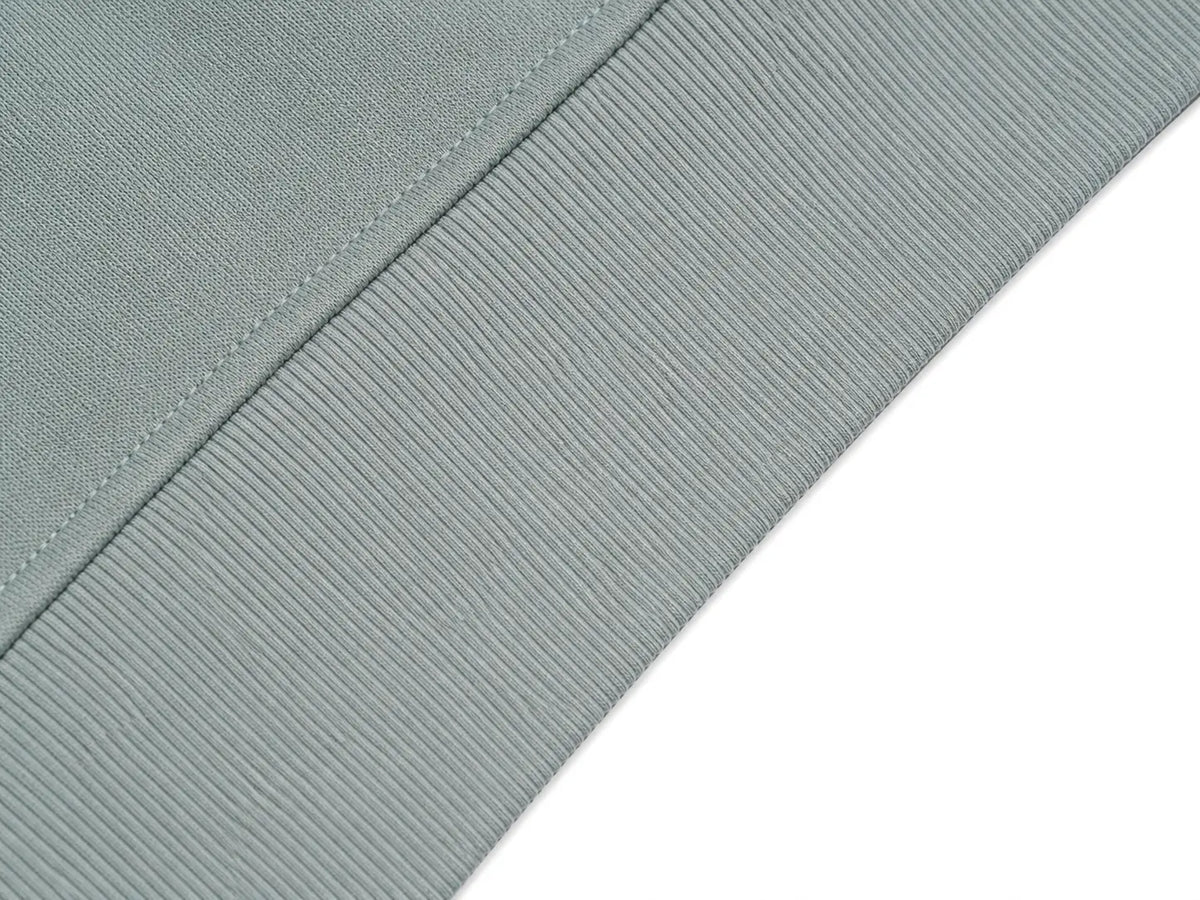 Close-up of a ribbed fabric cuff in a muted sage green color, showing the texture and stitching detail against a white background. TCH Floral Bird Embroidery Oversized Sweatshirt