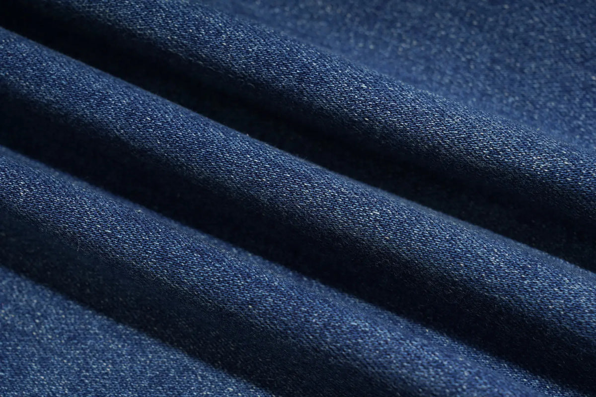 A close-up of dark blue textured fabric with soft diagonal folds and a fine woven or knit surface. TCH Floral Print Wide-Leg Denim Jeans