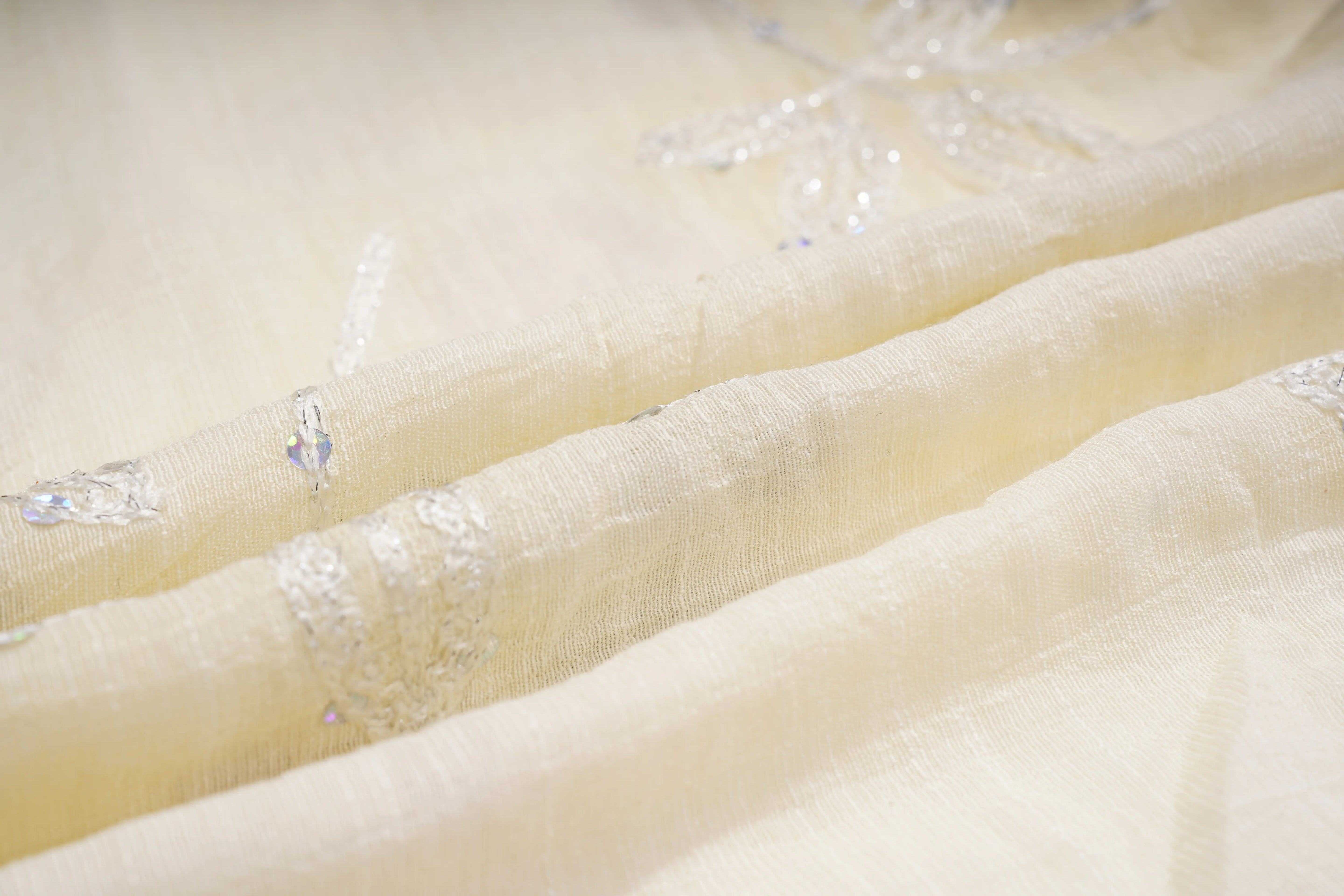Close-up of beige fabric with small decorative elements, TCH Floral Rhinestone Embellished V-Neck Blouse