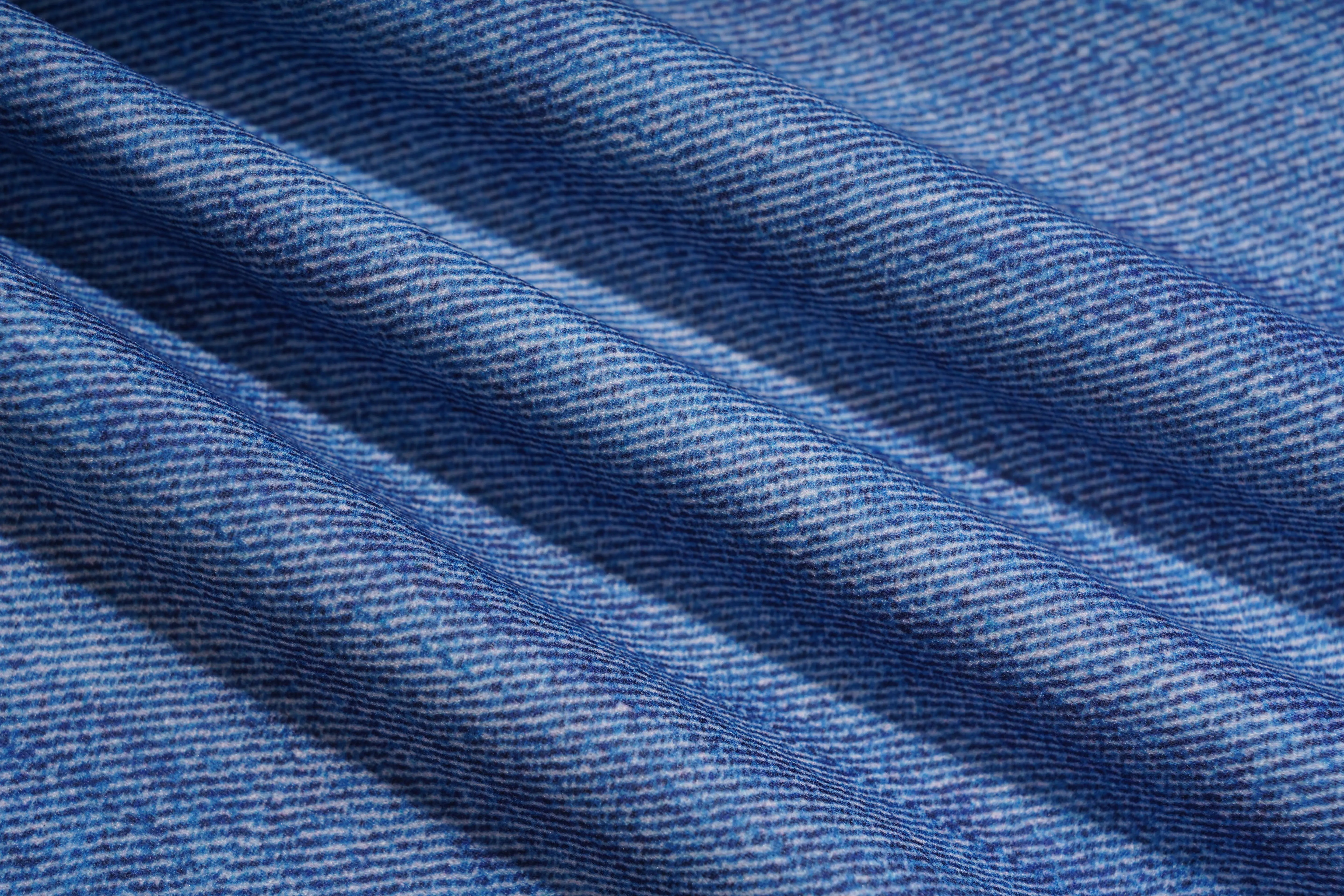A close-up of blue denim fabric with a diagonal twill weave and soft folds. TCH Floral Rhinestone Wide Leg Denim Jeans