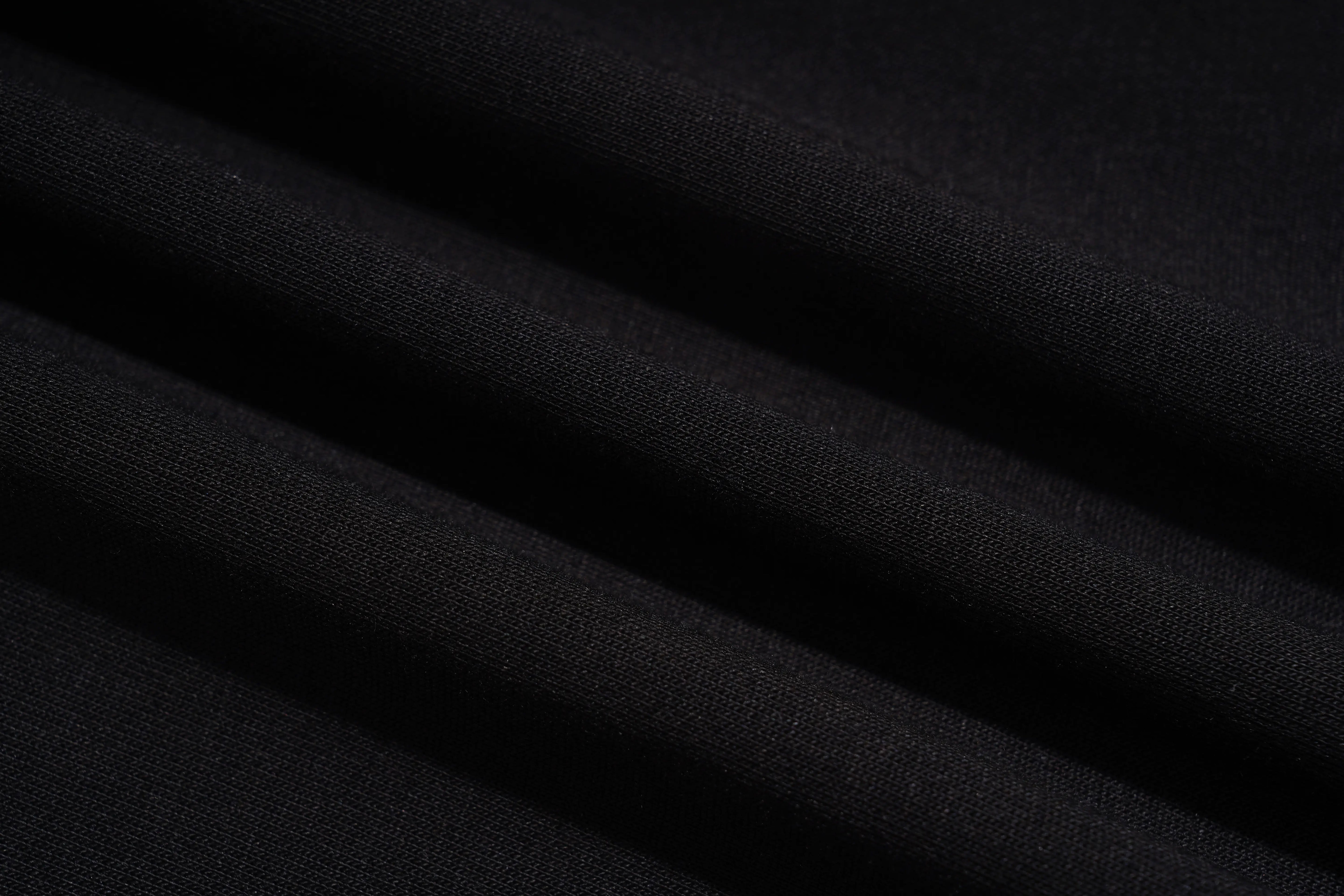A close-up of draped black fabric with soft folds showing a fine woven texture. TCH Galaxy Rhinestone Wide Leg Sweatpants