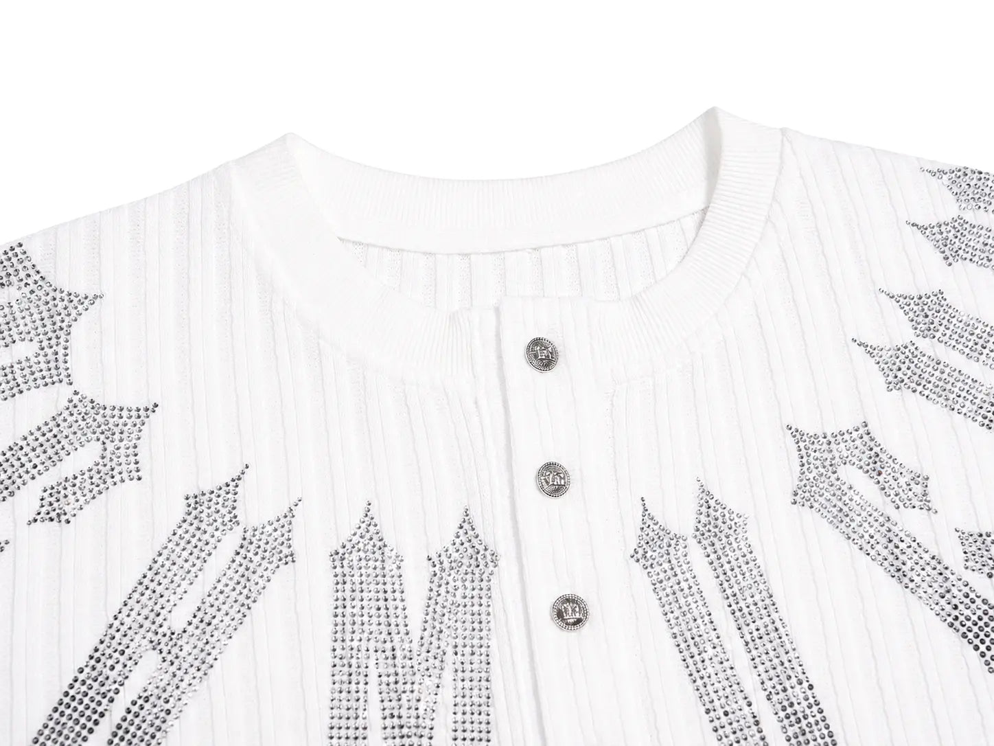 Close-up of a white ribbed knit top with a round neckline, three silver buttons, and large gothic-style letter 'M' embellishments outlined with silver rhinestones on the front. TCH Gothic Rhinestone Letter Ribbed Henley T-Shirt
