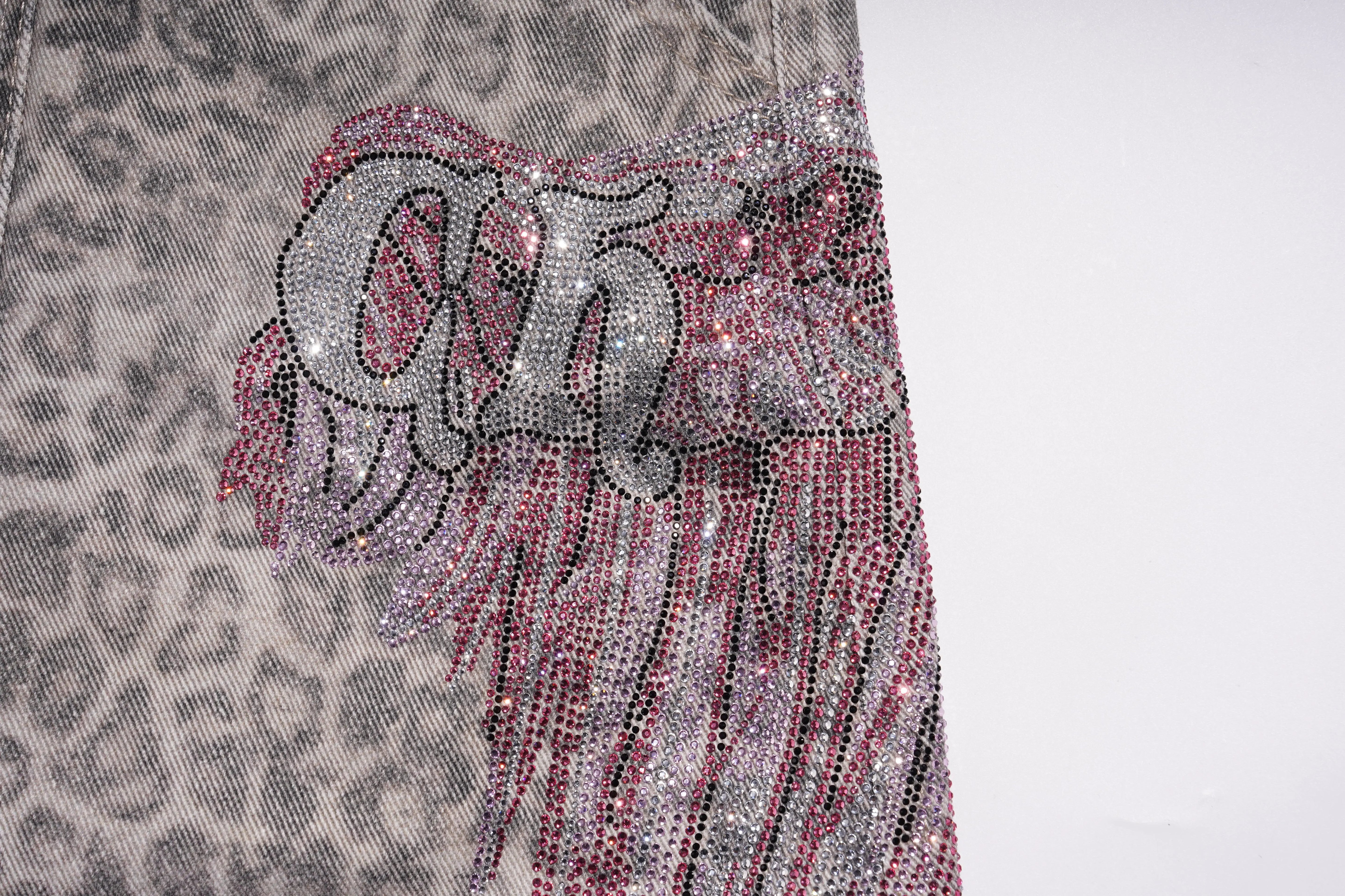 Decorative fabric with rhinestone design on a textured background, TCH Grey Leopard Rhinestone Wings Wide-Leg Jeans