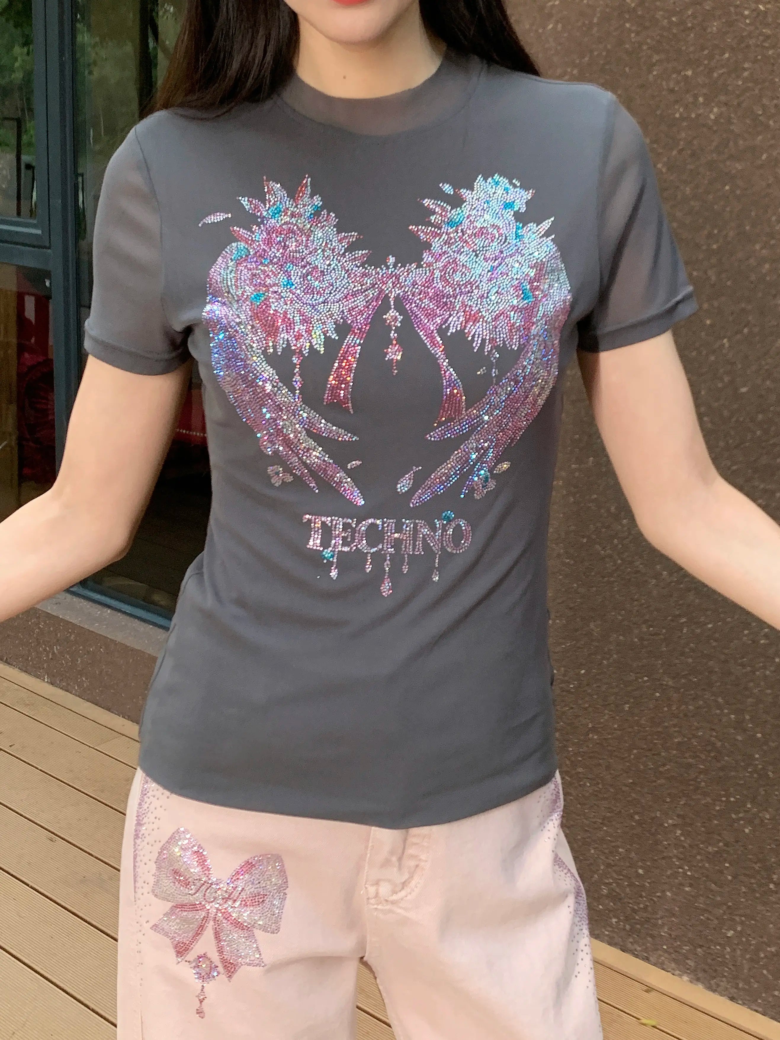 Person wearing a gray t-shirt with colorful graphic design and 'TECHNO' text. TCH Grey Rhinestone Pink Wings Graphic T-Shirt