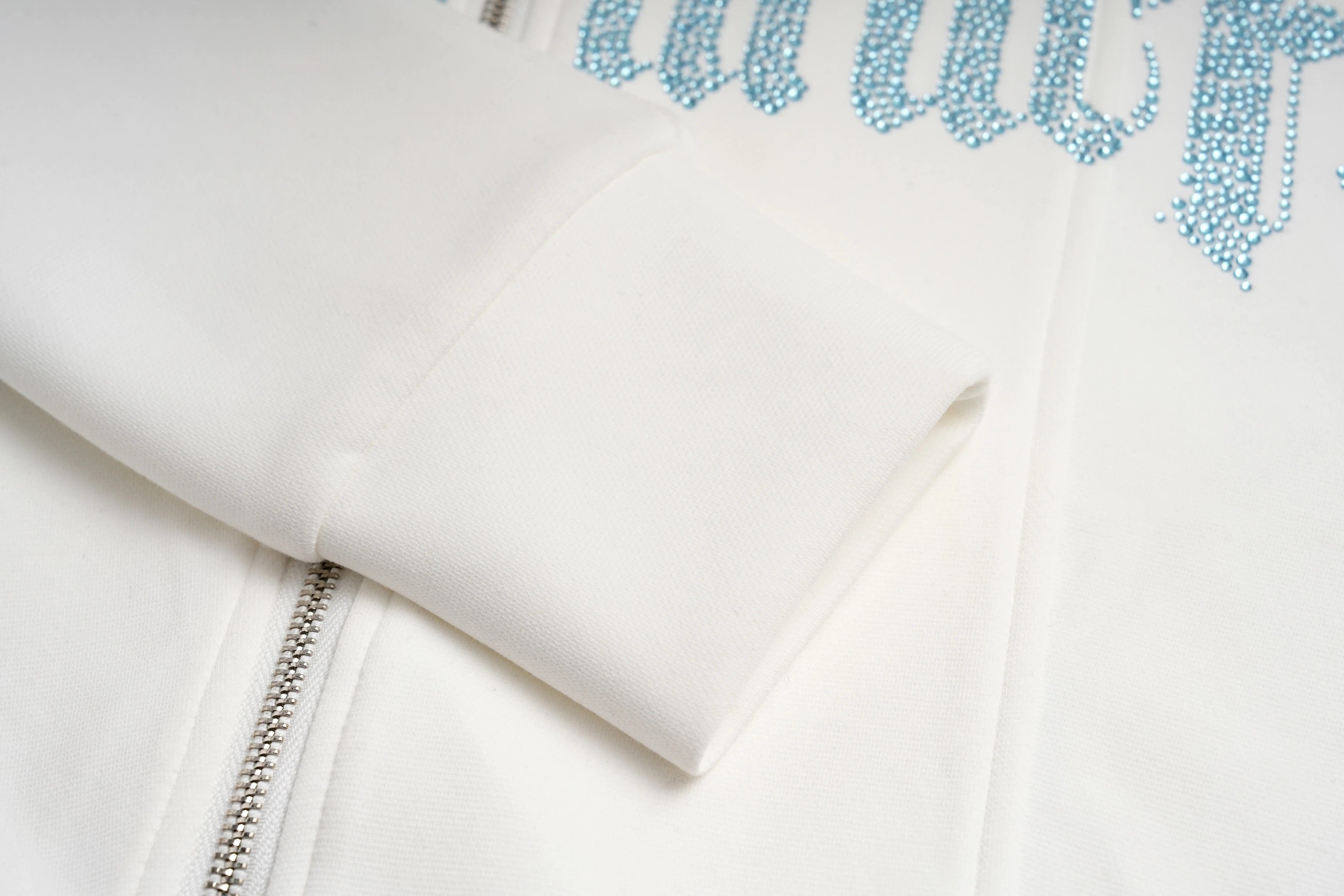 White hoodie with blue text and zipper on a light gray background, TCH Ice Blue Rhinestone Bow Zip-Up Jacket