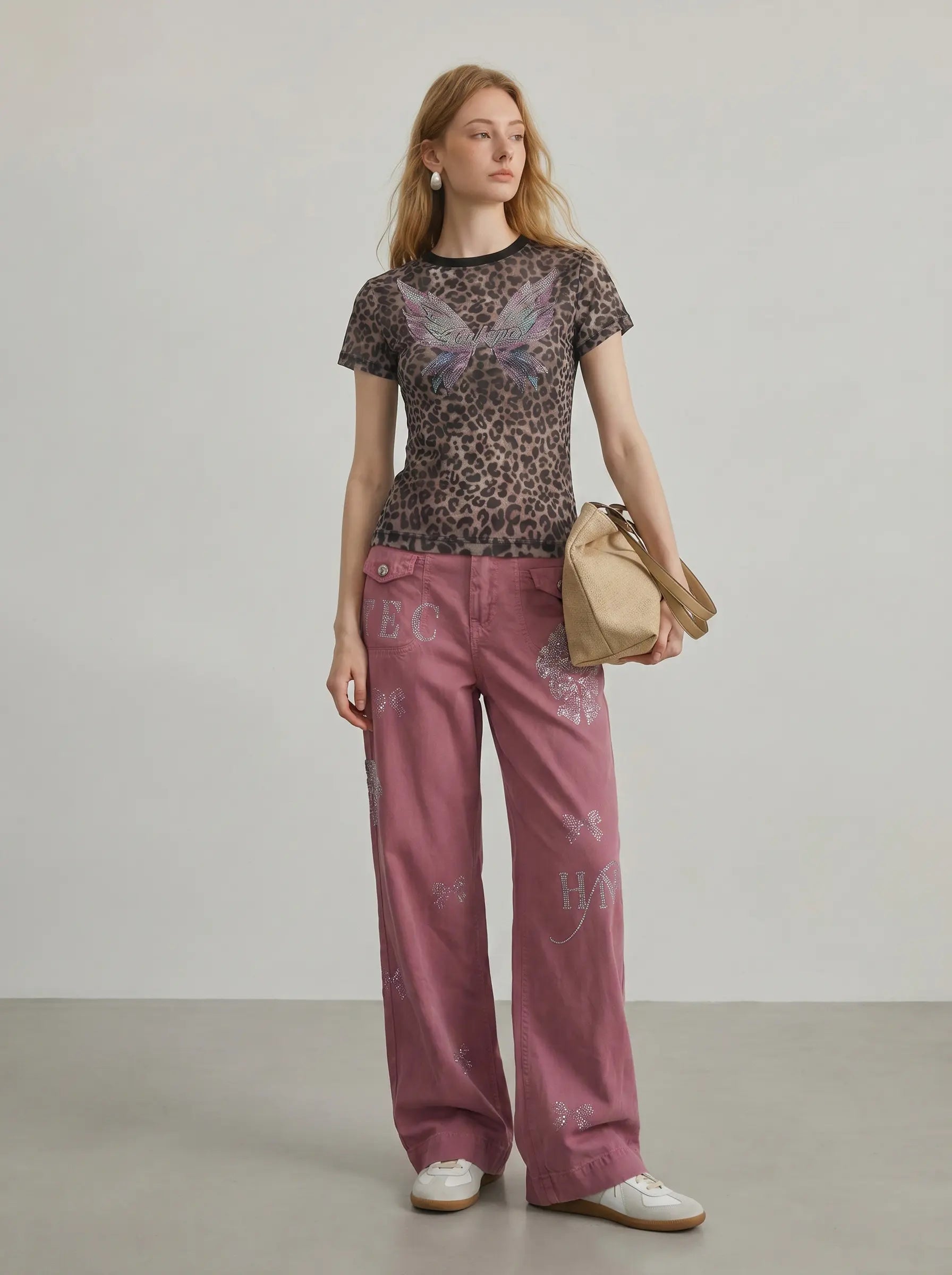 Woman wearing a patterned top and pink pants with 'BC' branding, standing against a plain background. TCH Leopard Print Rhinestone Butterfly Fitted T-Shirt
