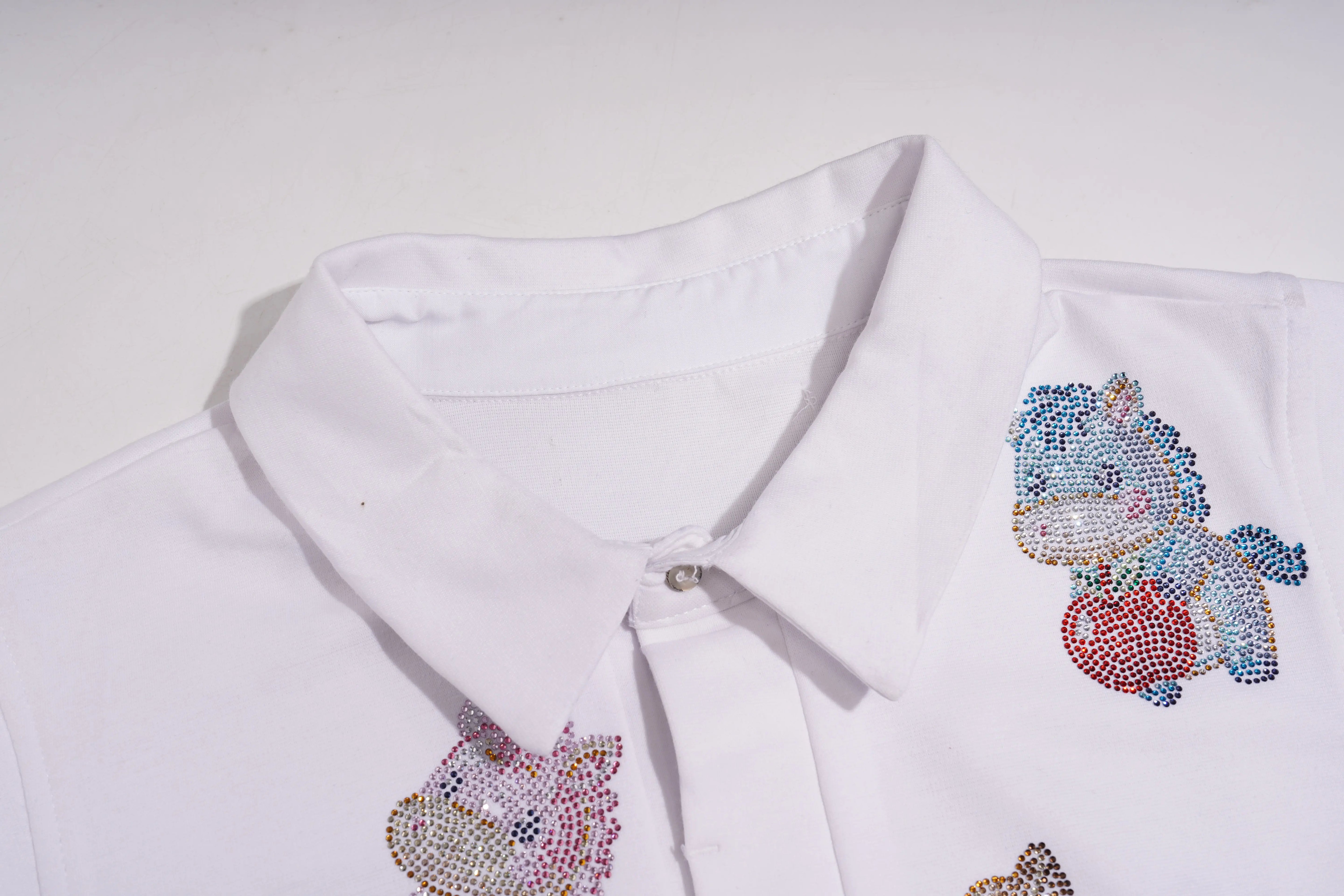 White polo shirt with colorful unicorn designs on a white background, TCH Lucky Pony Rhinestone Sleeveless Polo Shirt