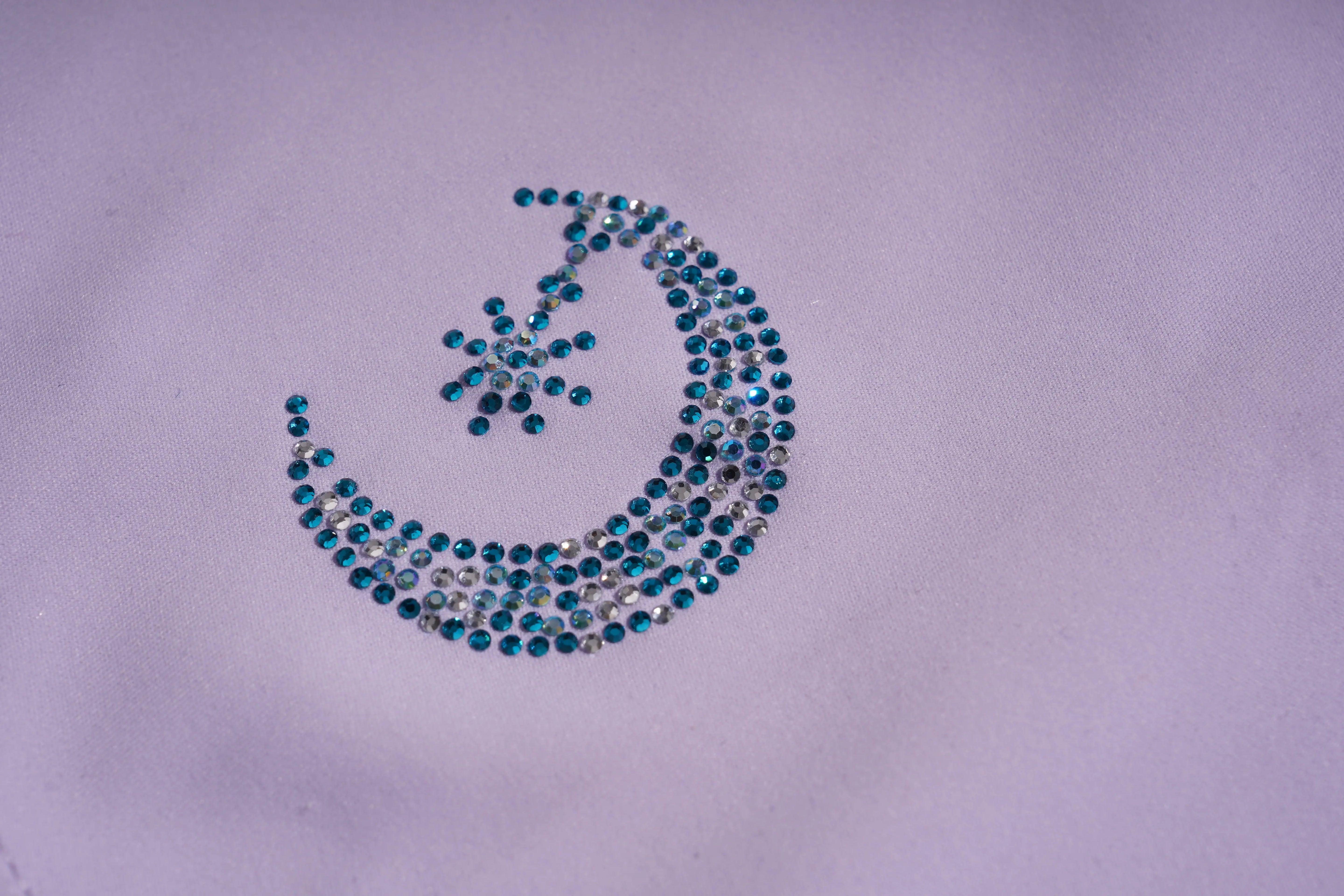 Decorative crescent moon design with blue stones on a light purple fabric background, TCH Moonlight Rhinestone Wide-Leg Pants
