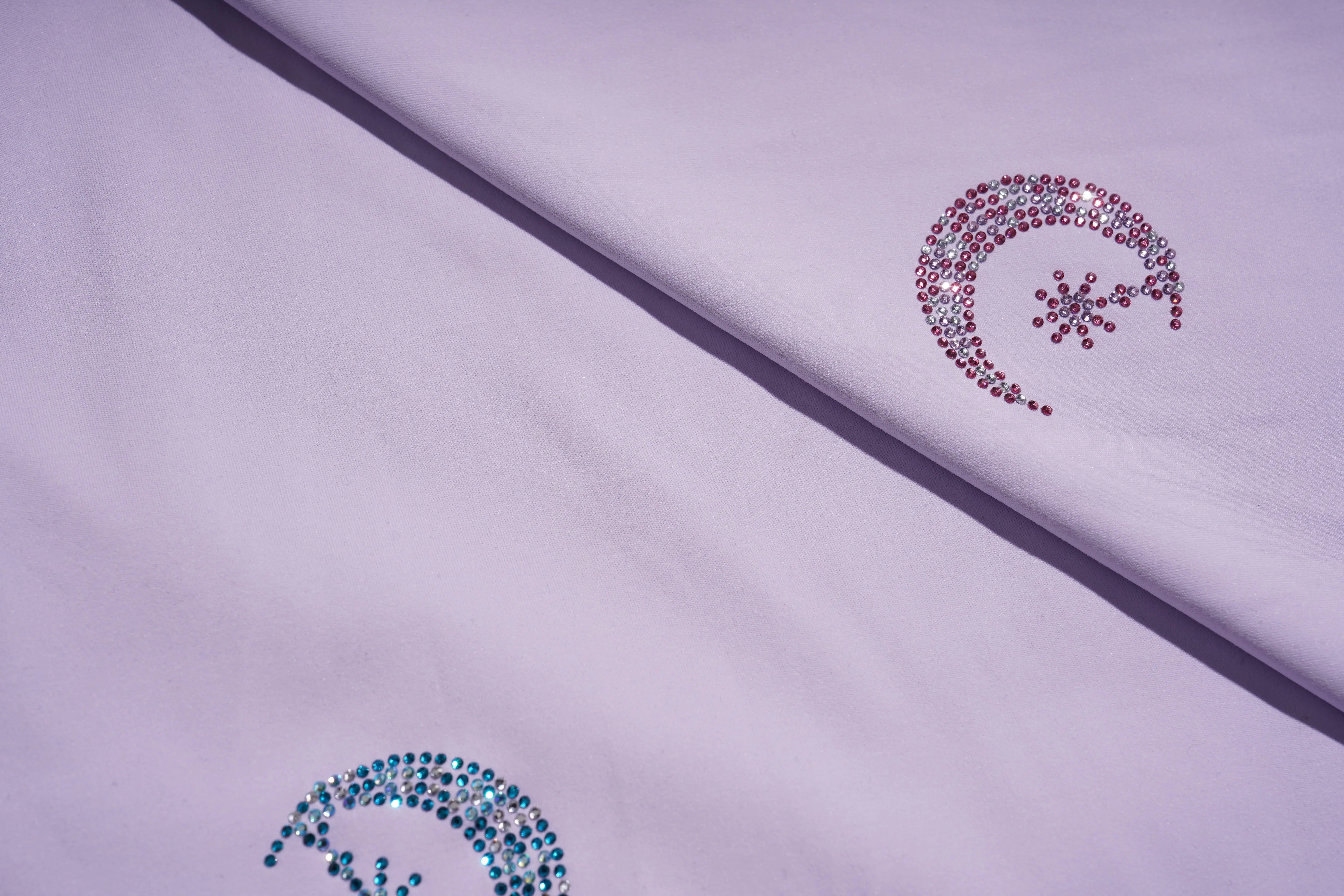 Decorative elements on a fabric surface with a purple border. TCH Moonlight Rhinestone Wide-Leg Pants