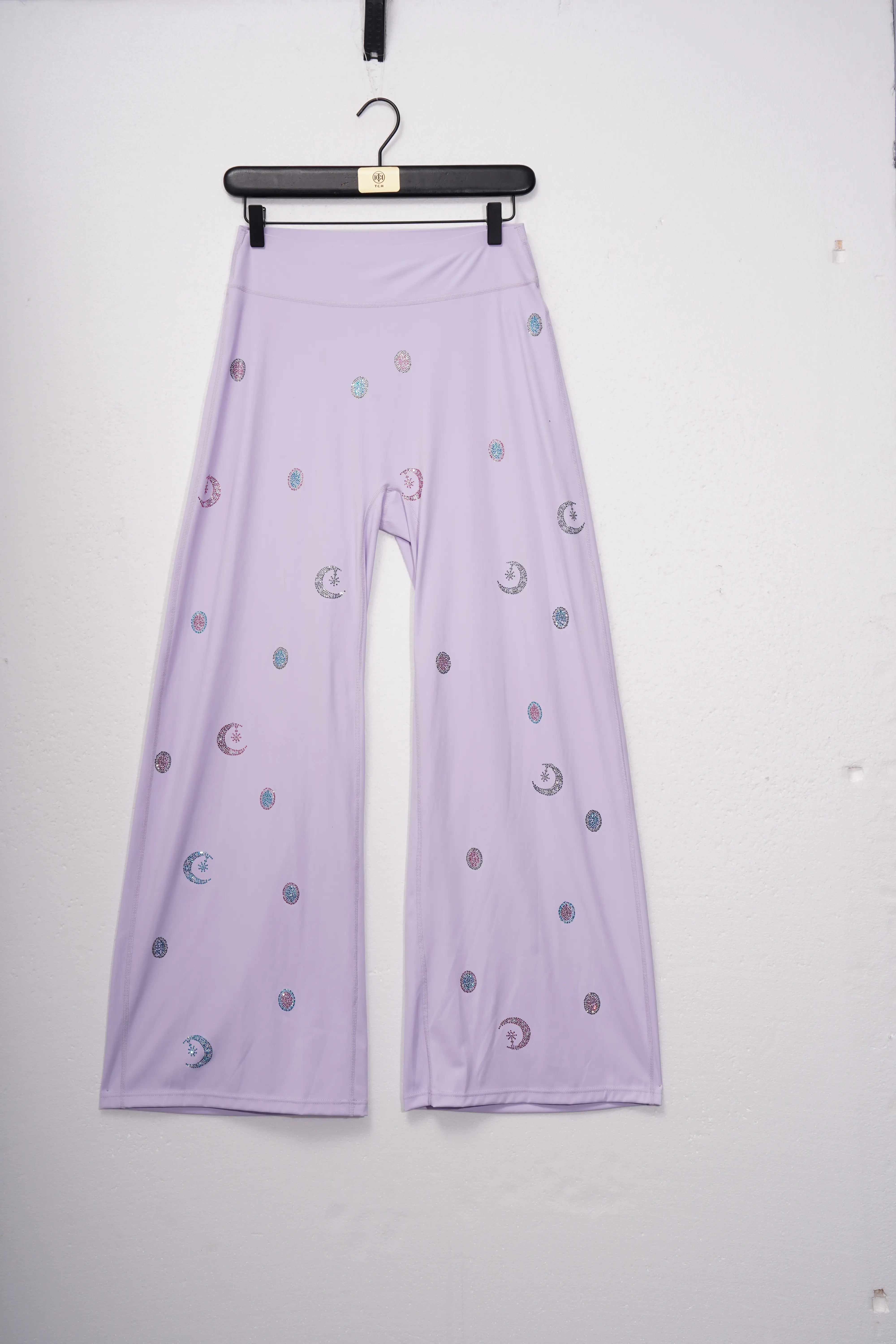 Lavender pants with moon and star patterns on a hanger against a white background, TCH Moonlight Rhinestone Wide-Leg Pants