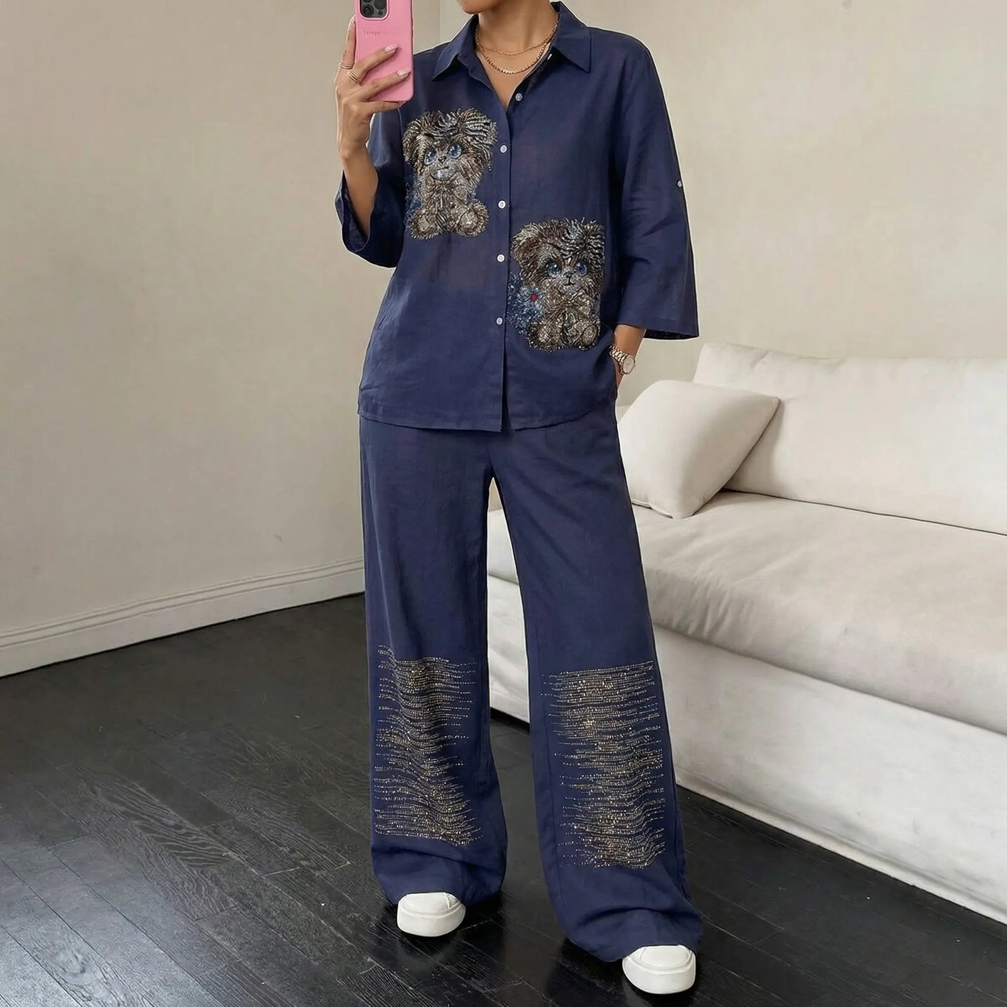 Person wearing a blue outfit with embroidered designs in a room with a beige sofa. TCH Navy Rhinestone Dog Matching Set