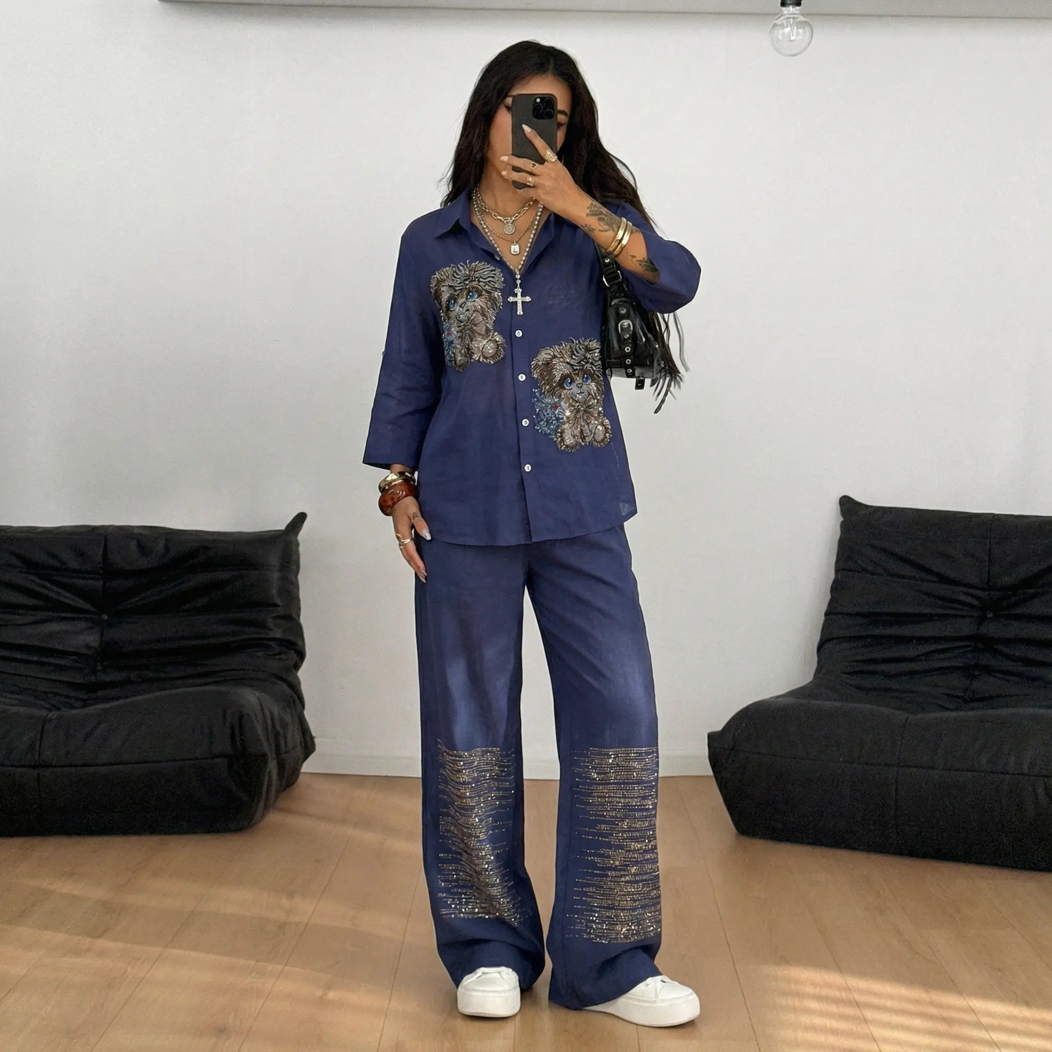 Person wearing a blue outfit with decorative elements in a room with black bean bags. TCH Navy Rhinestone Dog Matching Set