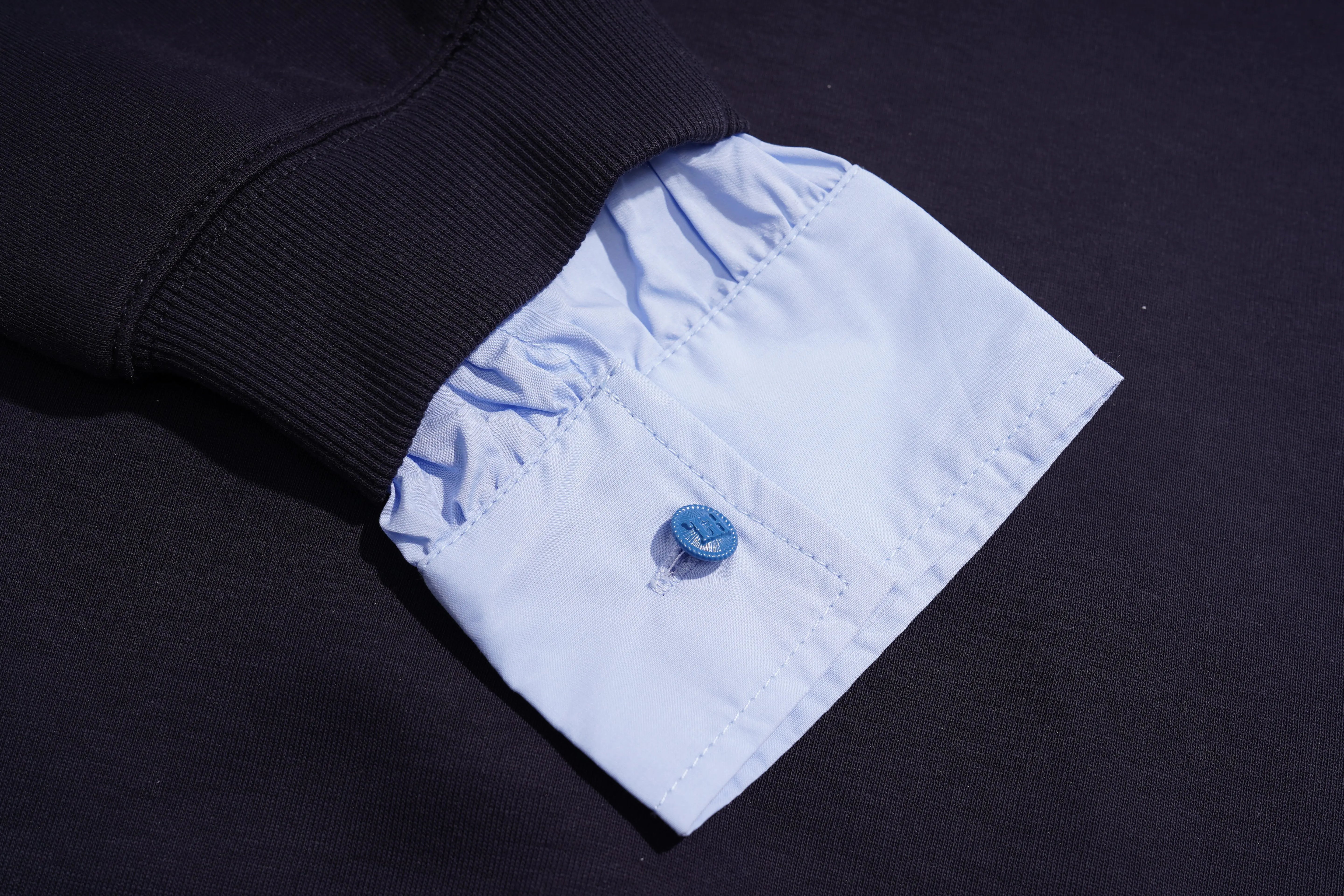 Close-up of a black garment with a white cuff featuring a blue button on a dark background, TCH Navy Sailor Bow Wings Rhinestone Two-Piece Set