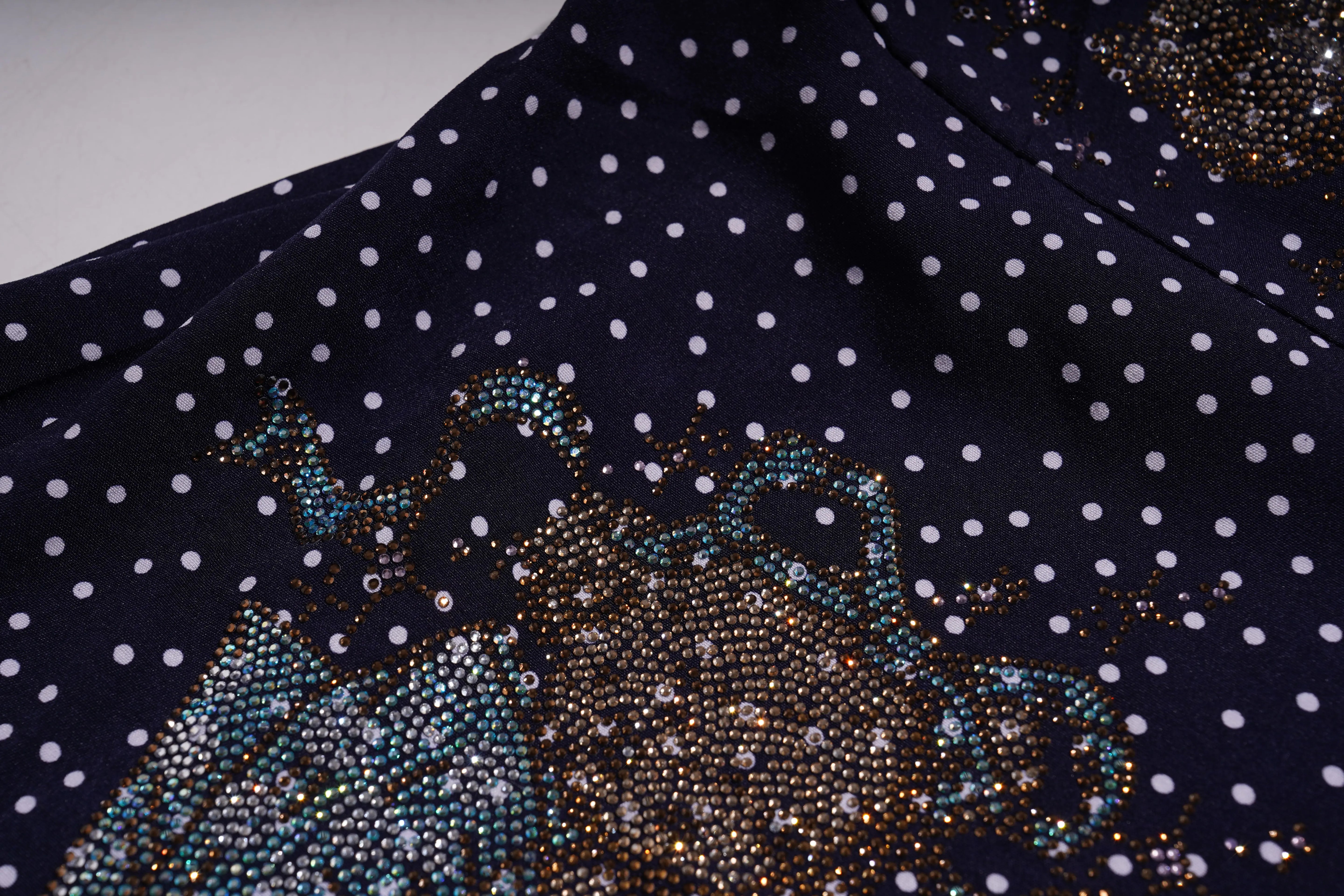 Navy blue fabric with white polka dots and a decorative pattern of reindeer and sleigh. TCH Navy Teddy Bear Bow Rhinestone Dress