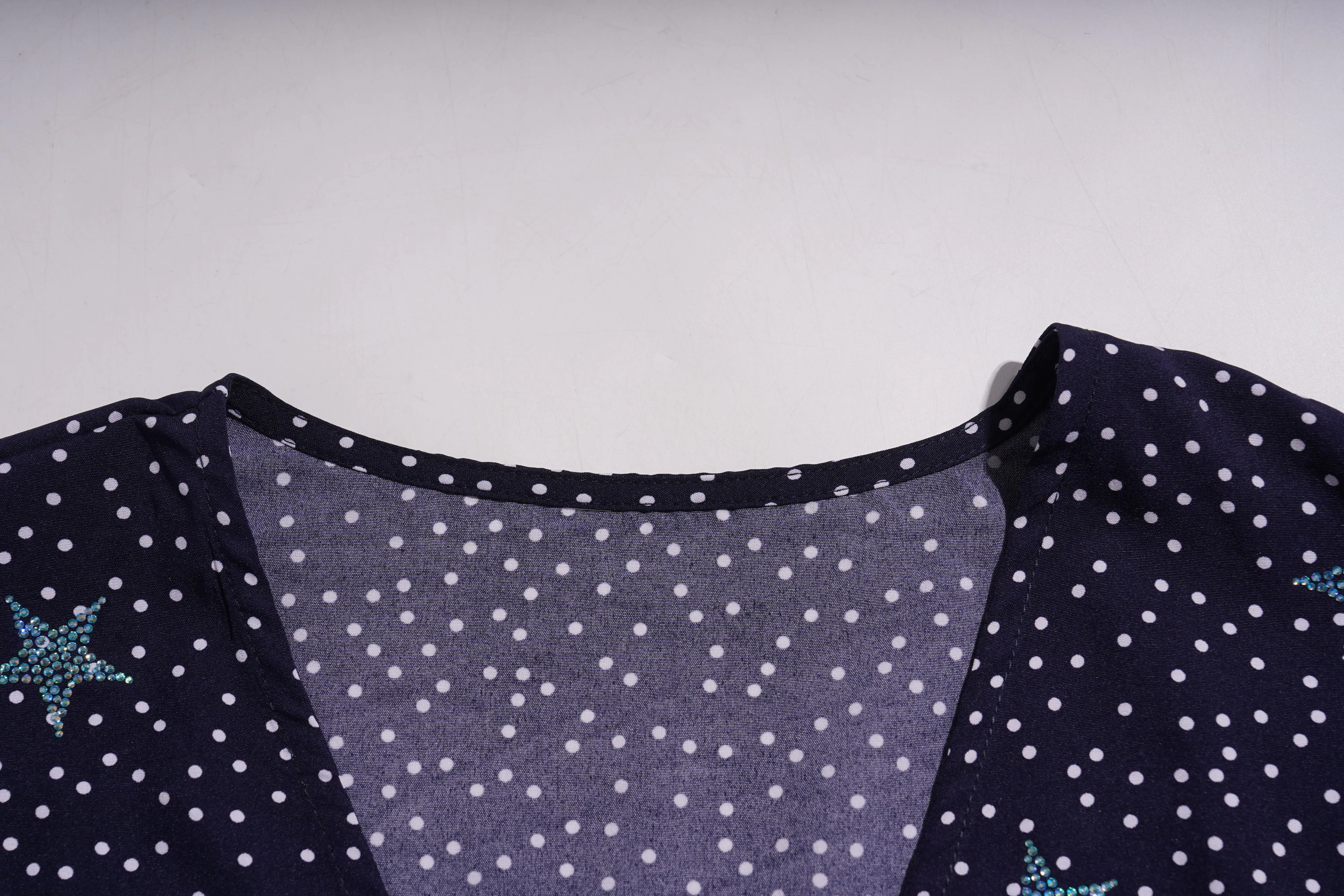 Navy blue fabric with white polka dots and turquoise star patterns on a light gray background, TCH Navy Teddy Bear Bow Rhinestone Dress