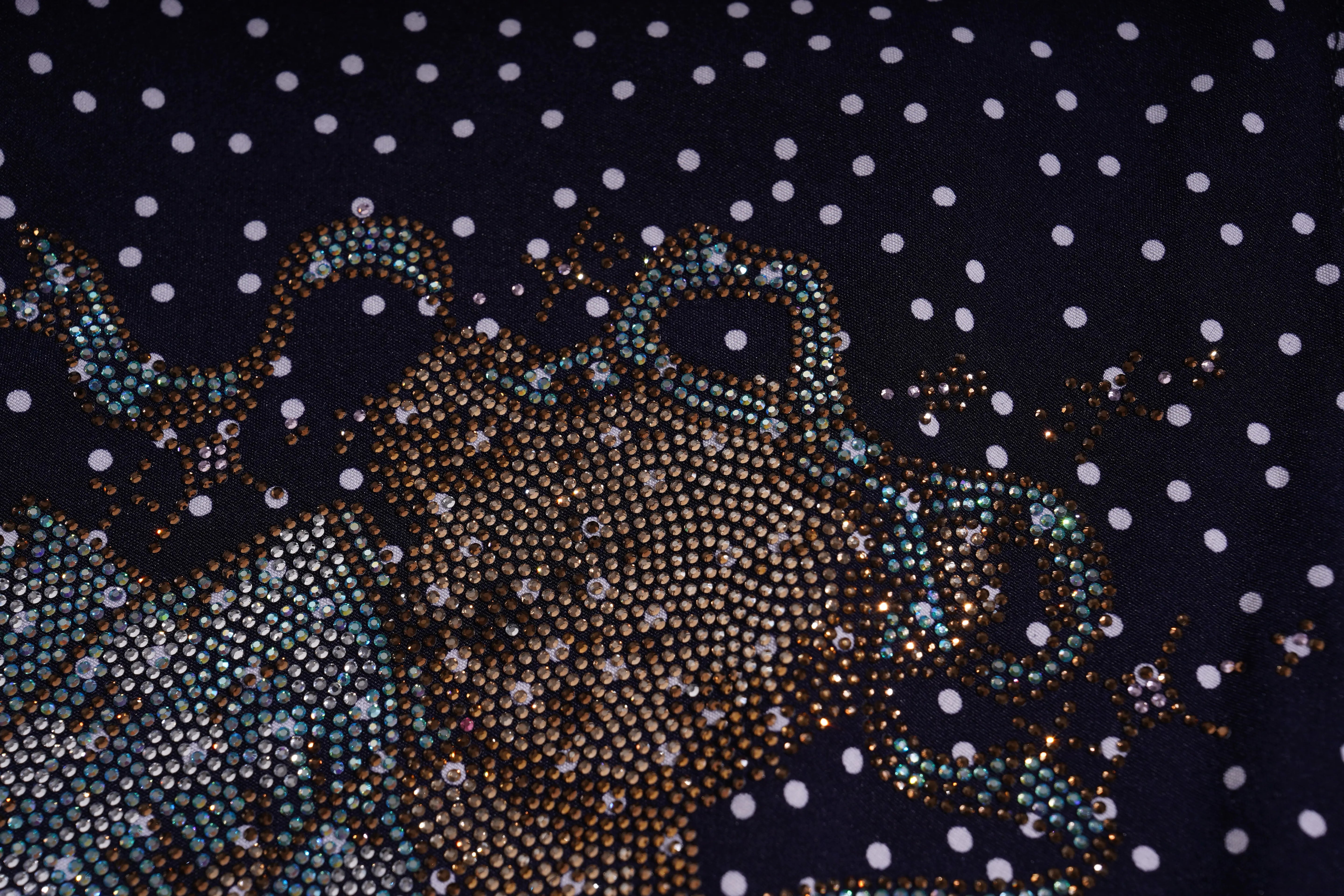 Close-up of a decorative fabric with a pattern of small white dots on a dark background. TCH Navy Teddy Bear Bow Rhinestone Dress