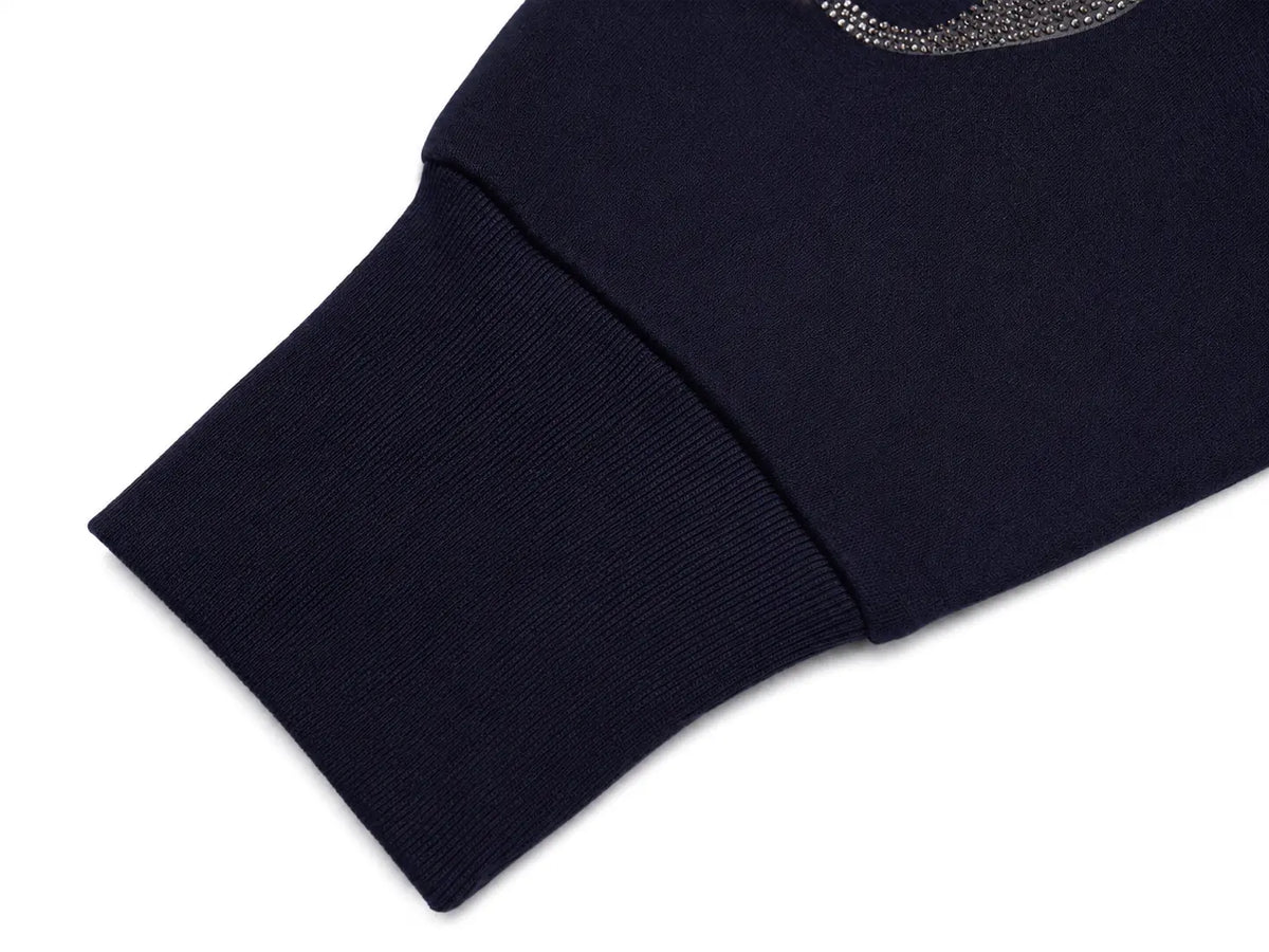 Close-up of a dark navy ribbed knit sleeve with a small silver rhinestone-embellished logo near the cuff, shown on a white background. TCH Navy Teddy Bear Rhinestone Zip Hoodie