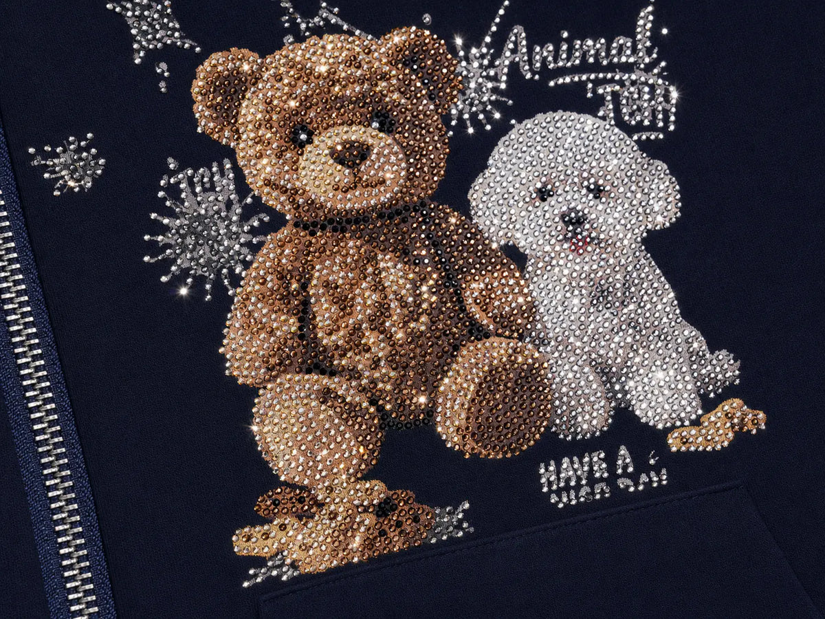 Close-up of a dark navy garment featuring a large rhinestone teddy bear and white puppy graphic with the text 'Animal have a nice day' and silver snowflake embellishments. TCH Navy Teddy Bear Rhinestone Zip Hoodie